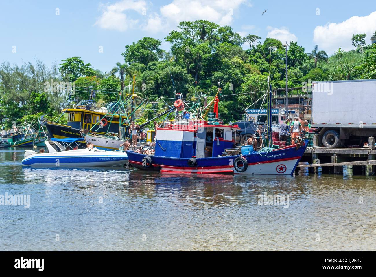 A boat is unloading fresh fish to the pier. The Jurujuba fishing community is part of the coast of the Guanabara Bay in Niteroi city, Rio de Janeiro, Stock Photo