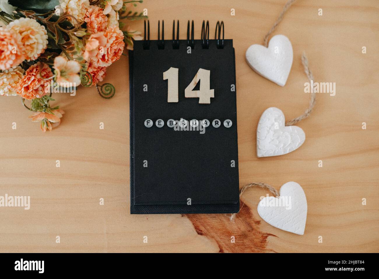 Wooden calendar on February 14 with roses and heart. Happy Valentines Day concept Stock Photo