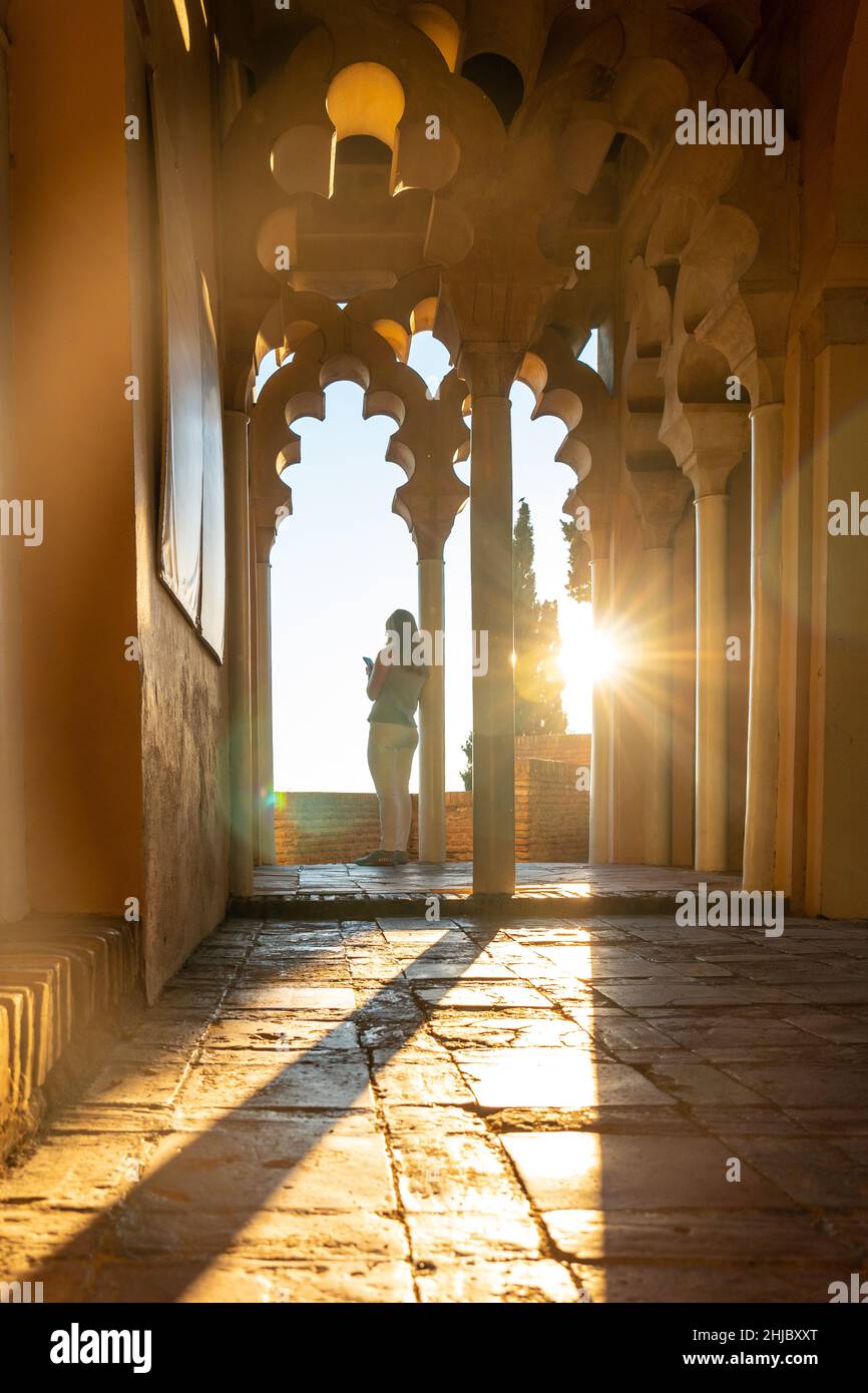 Tourist hunched over a column of the Arab doors of a courtyard of the ...
