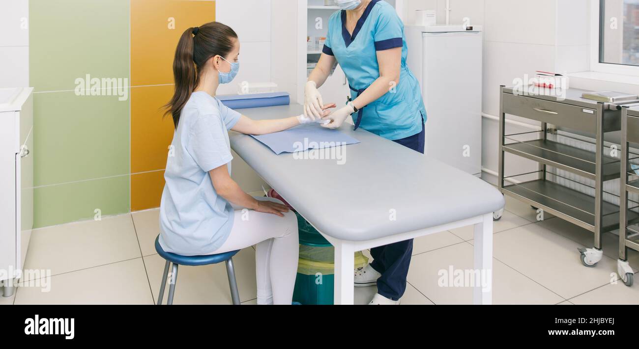A doctor wrapped around the wrist for first aid close-up. Application of bandages on the patient's hands, first aid concepts and wrist injury Stock Photo