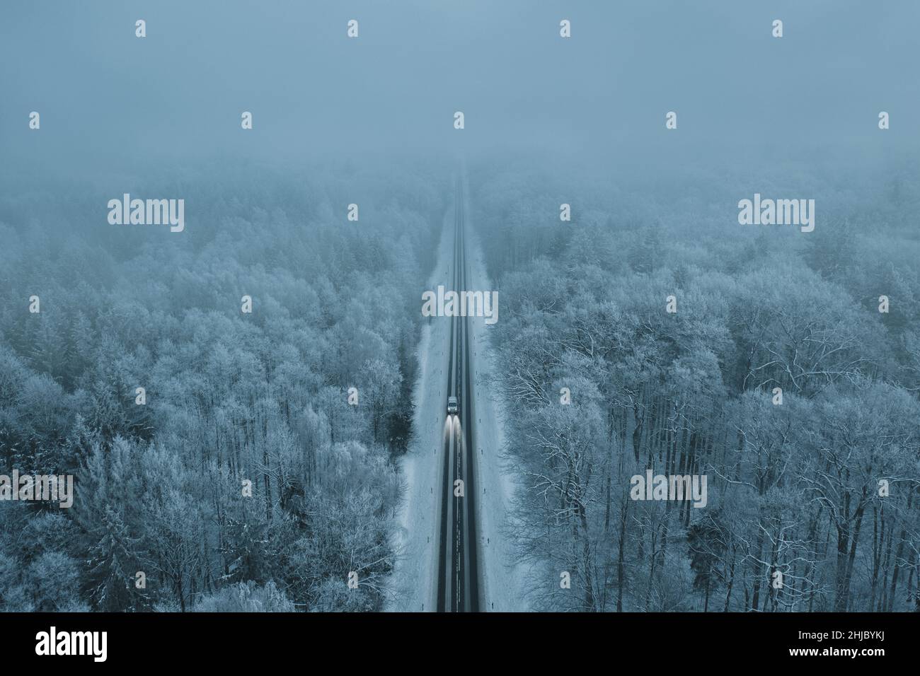 High angle view of a car on the road trough the winter forest with copy space Stock Photo