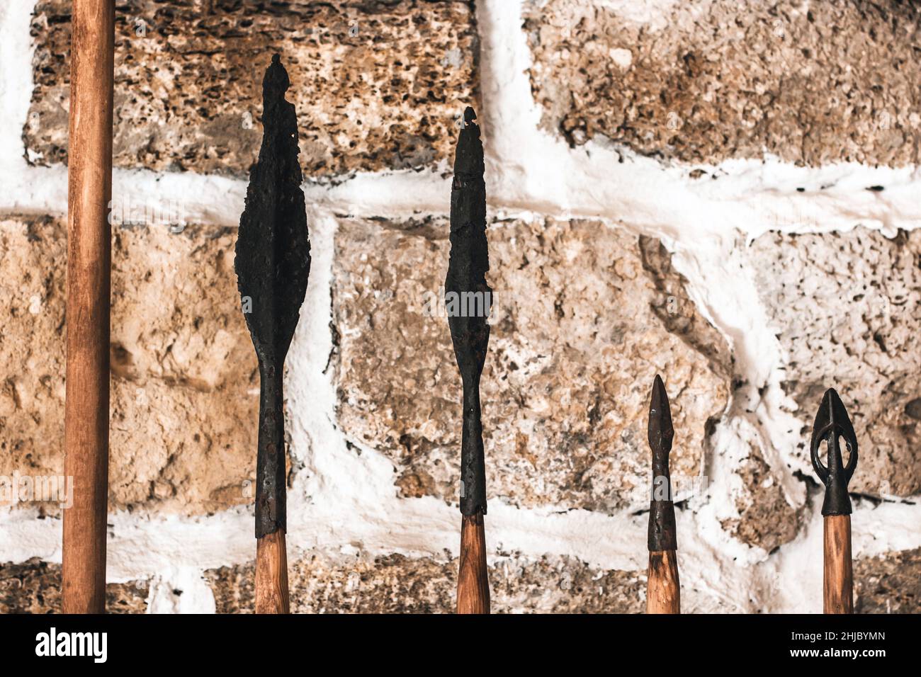 Spearheads. Old spears on the background of the wall. Spear tips. Old
