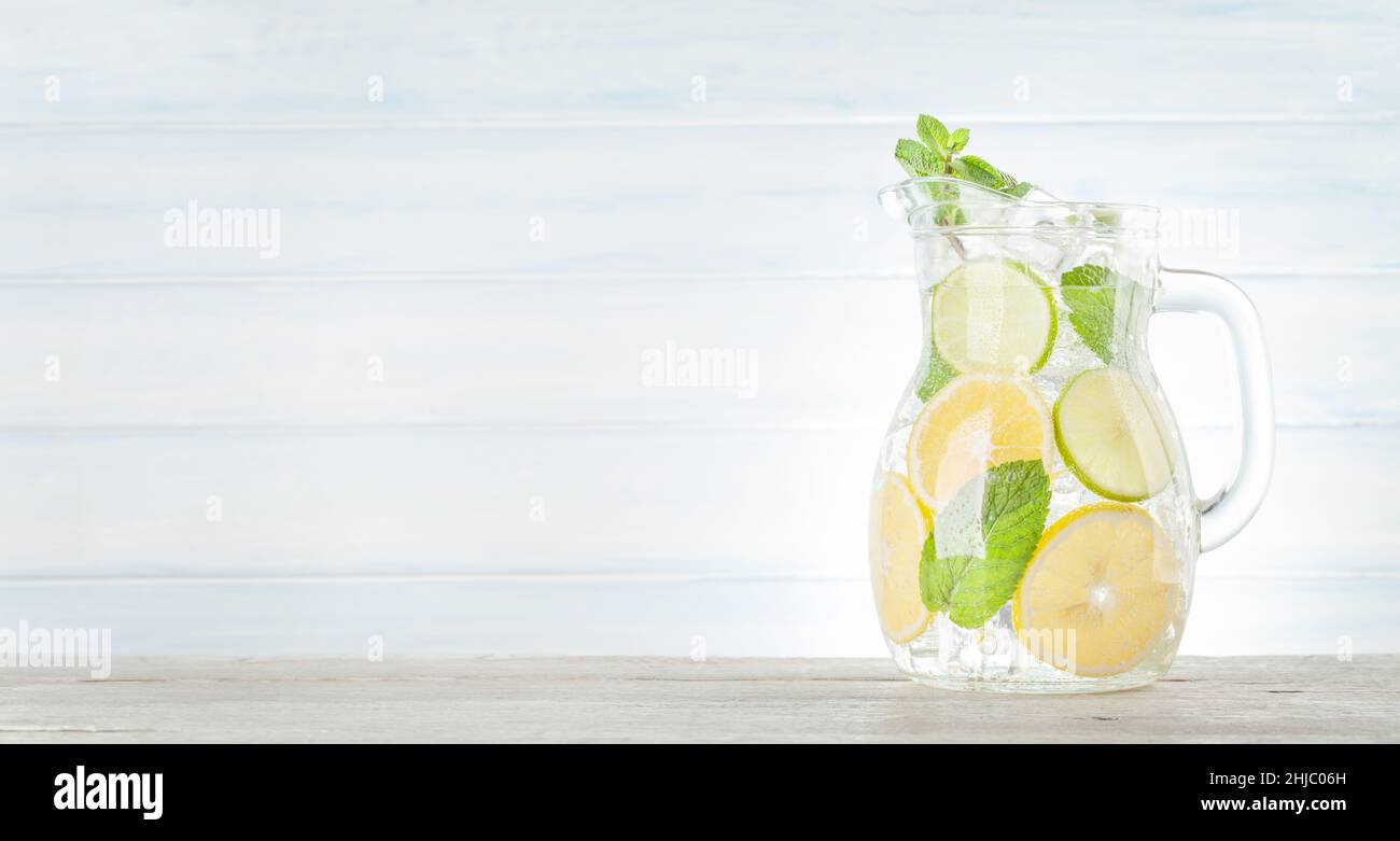 Lemonade pitcher with lemon, mint and ice cubes. With copy space Stock Photo