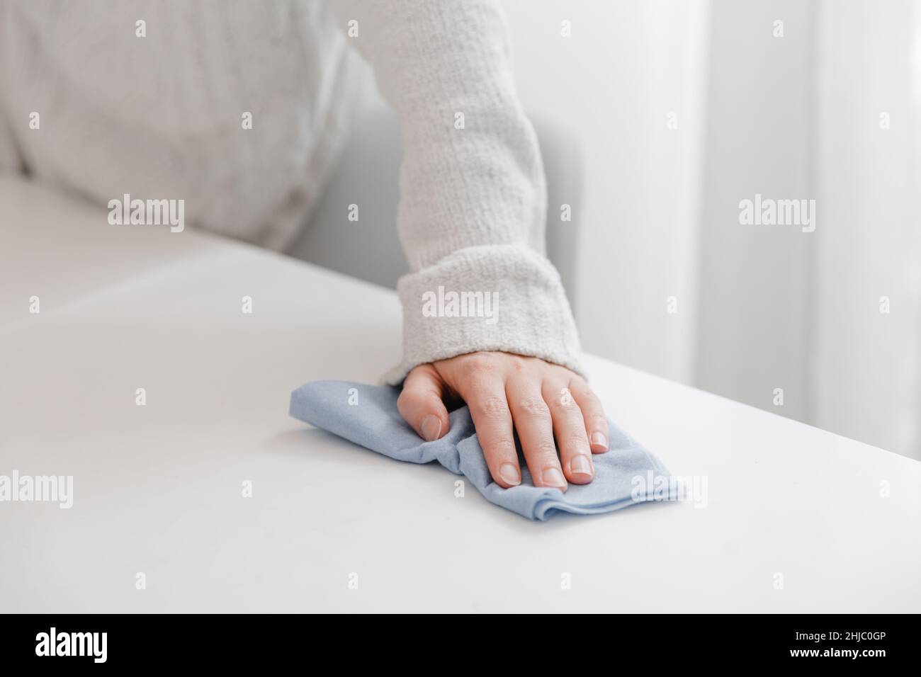 Cleaning the table with a blue microfiber cloth. Sanitize surfaces