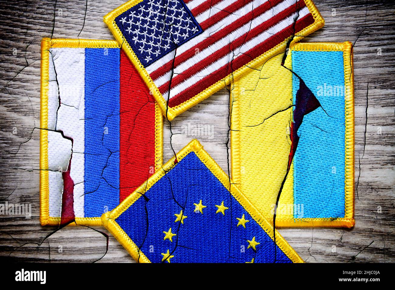 Flags of Russia, Ukraine, the United States and the EU on broken ground, Ukraine crisis Stock Photo