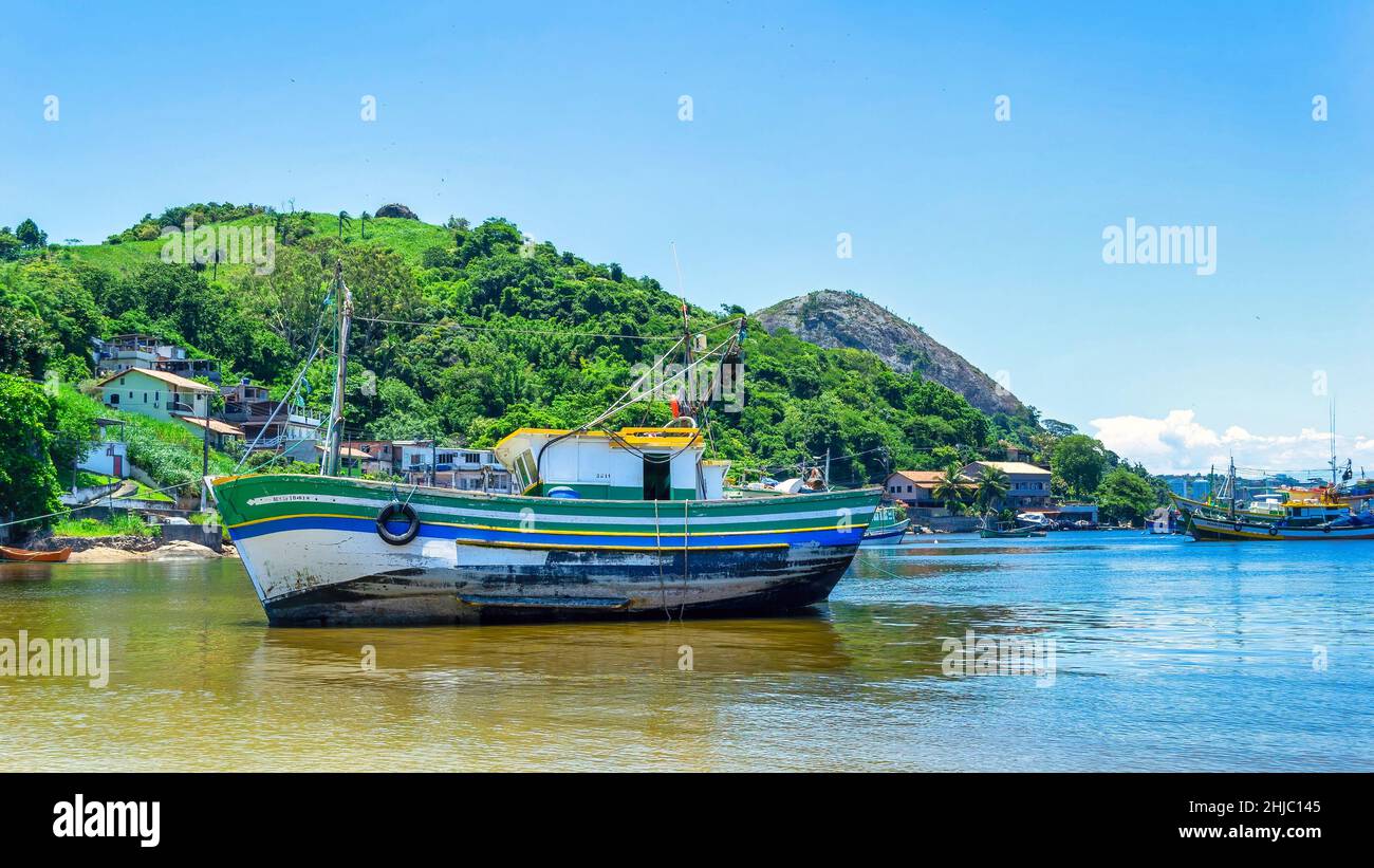 Large fishing boat by the coast with a hill in the background. The Jurujuba fishing community is part of the coast of the Guanabara Bay in Niteroi cit Stock Photo