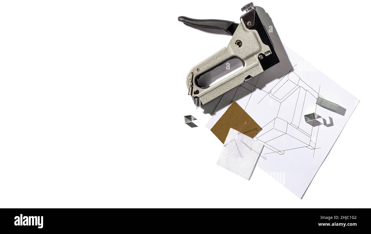 Silver furniture stapler gun with staples and the drawing of the armchair. Manual industrial tool. Top view with copy space for text Stock Photo