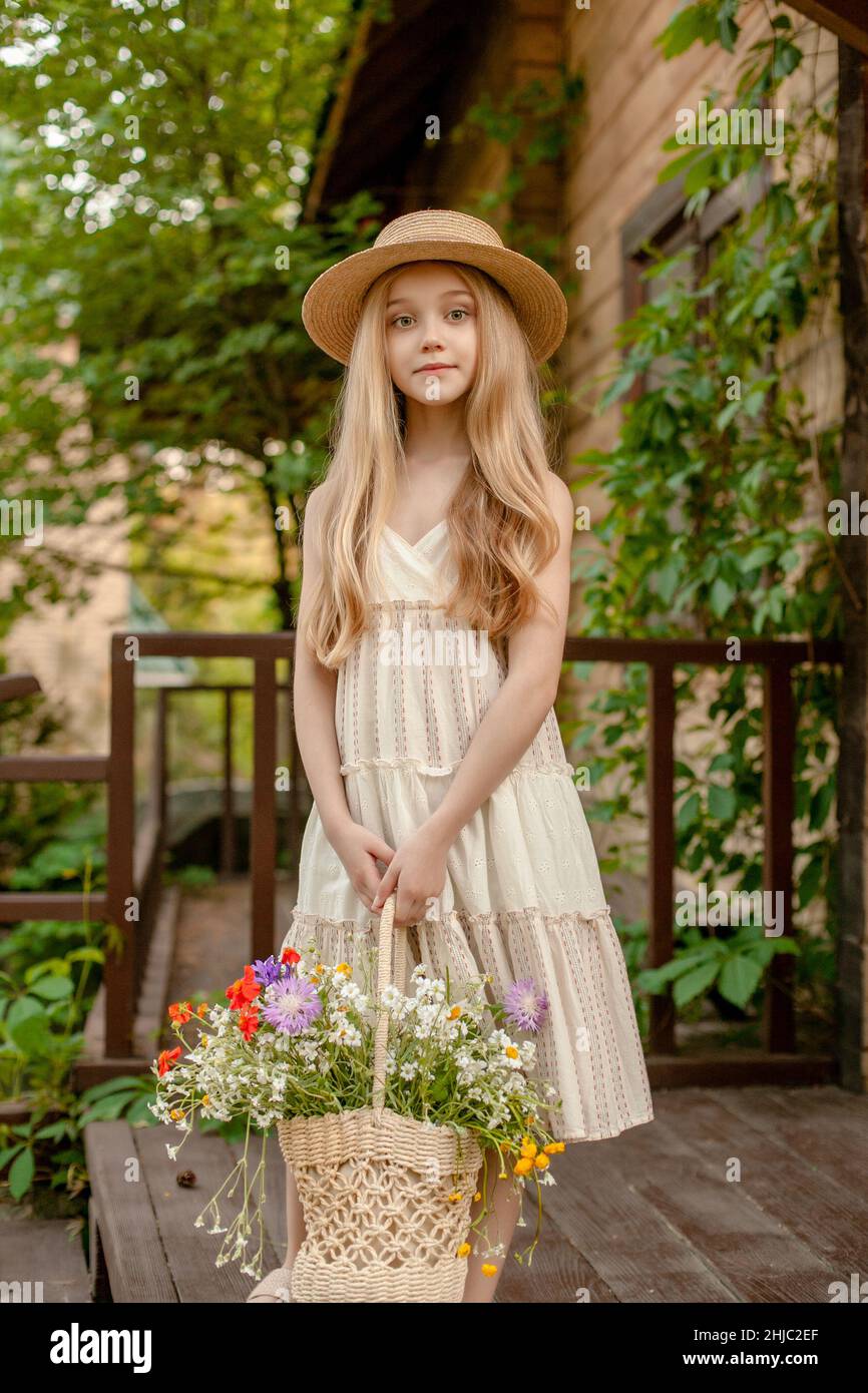 Tween girl with basket of colorful wildflowers enjoying vacation in