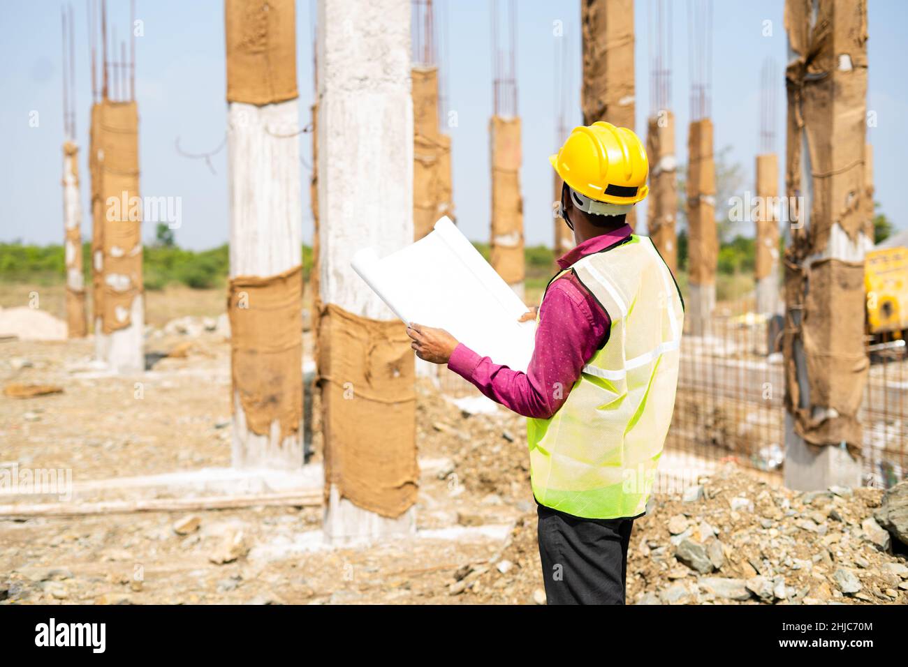 young indian engineer or supervioser inspecting construction plan at workplace - concept of skilled labour,daily wager lifestyle and construcation Stock Photo