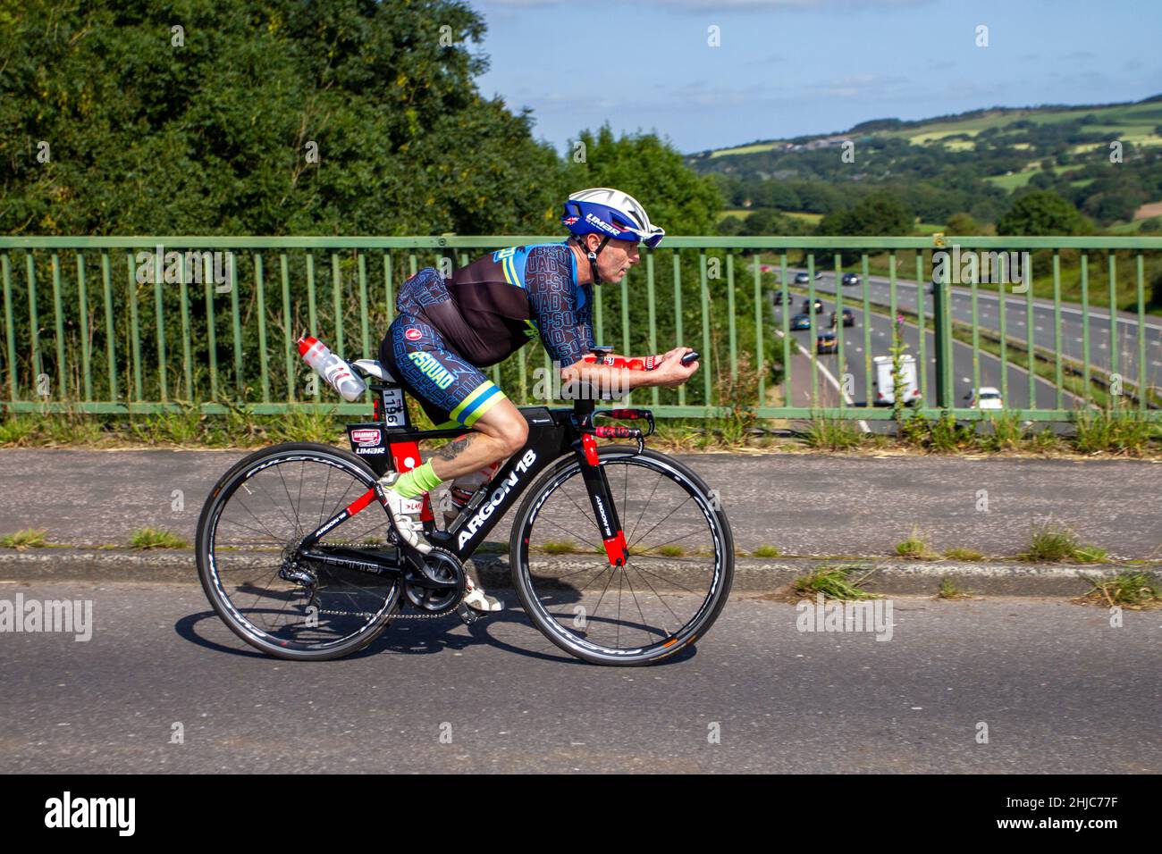Argon 18 Canadian superior quality road, gravel, triathlon and track bikes; Male cyclist riding sports road bike on countryside route crossing motorway bridge in rural Lancashire, UK Stock Photo