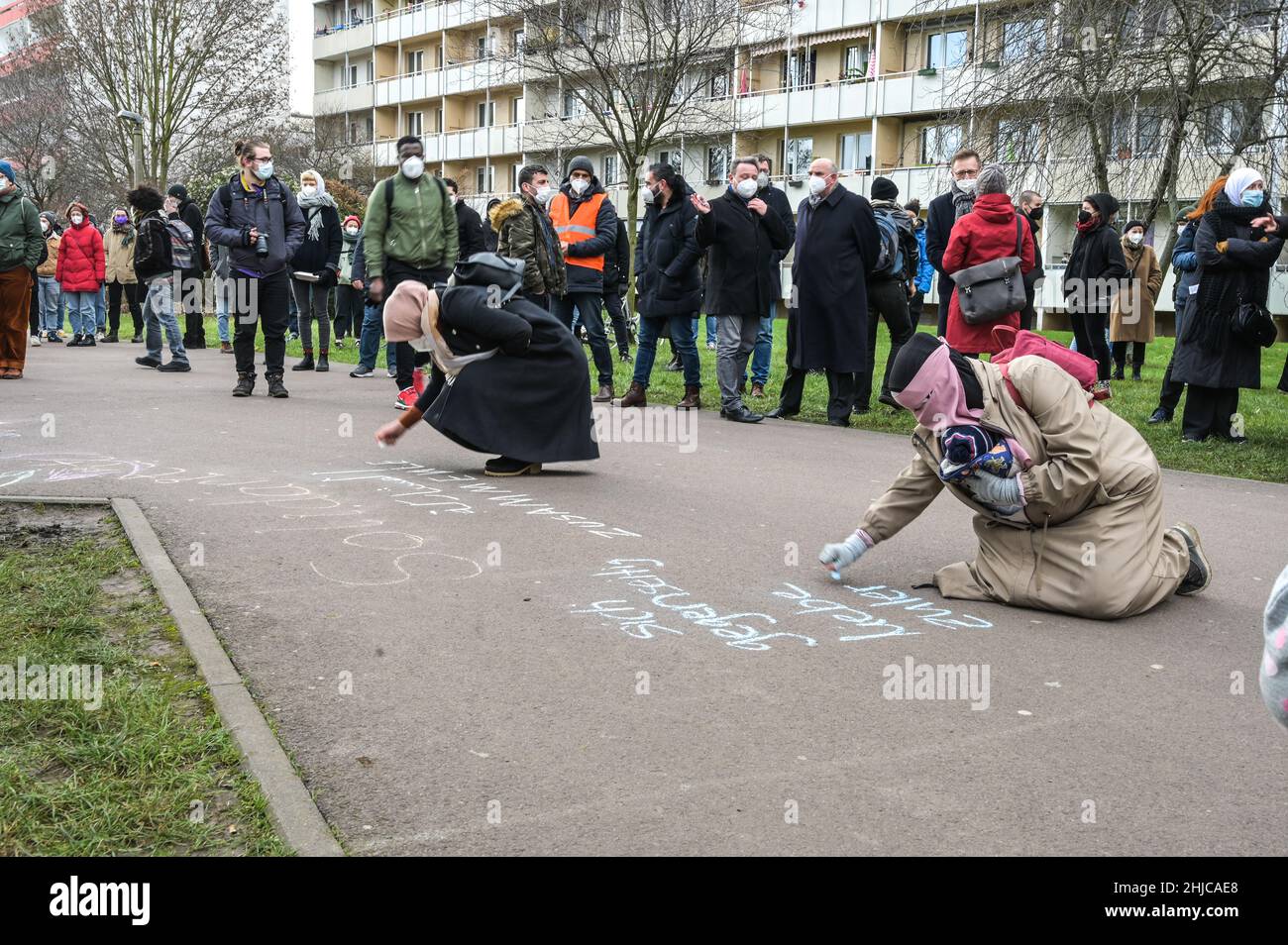 28 January 2022, Saxony-Anhalt, Halle (Saale): People stand in front of the  Islamic Cultural Center in Halle-Neustadt during an event. Two Muslim  participants write their wishes for a peaceful coexistence of religions