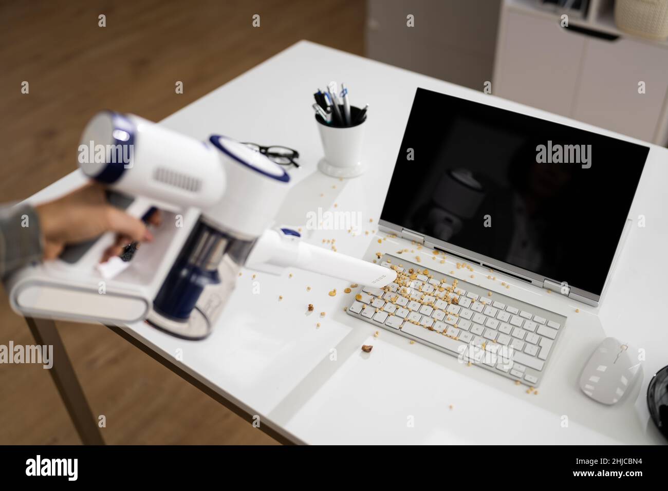 Cleaning Office Desk Using Cordless Vacuum Cleaner Stock Photo Alamy