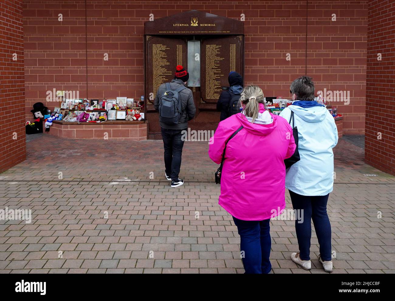Passers-by take photographs of the updated monument after Andrew Devine ...