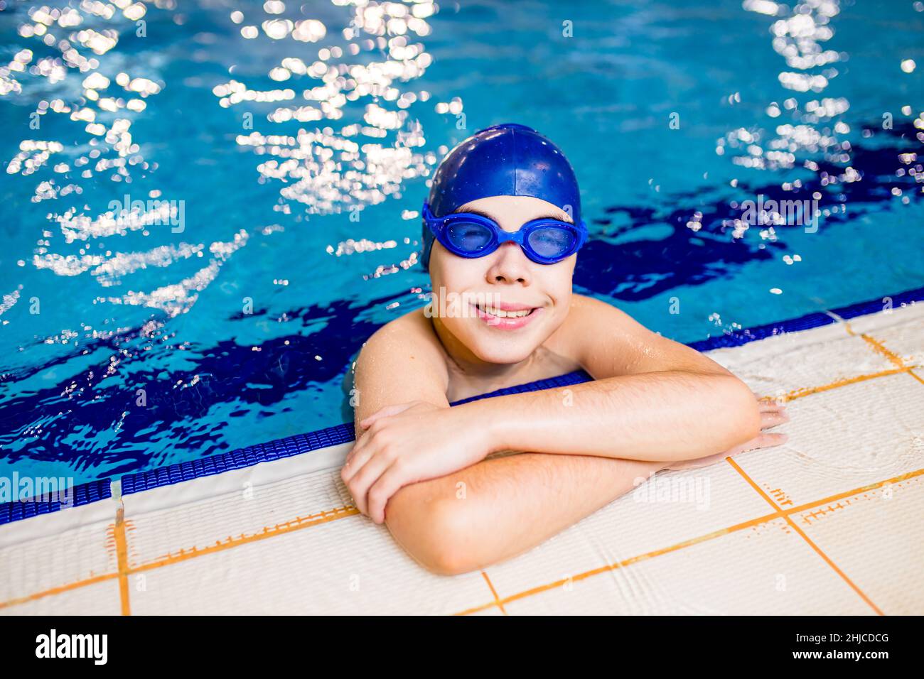 Disabled boy with Down syndrome in swimming cap with goggles Stock