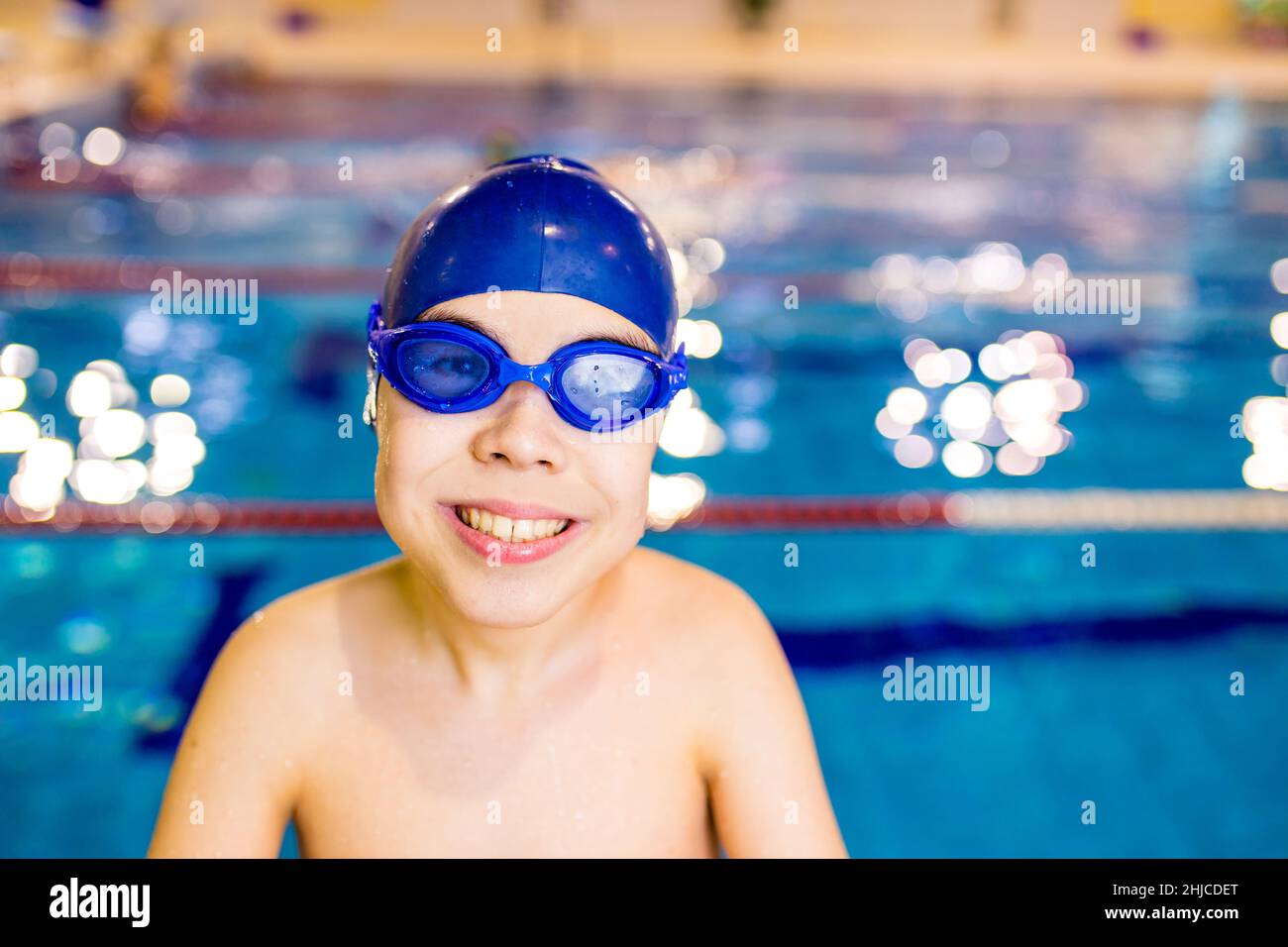 Disabled boy with Down syndrome in swimming cap with goggles Stock