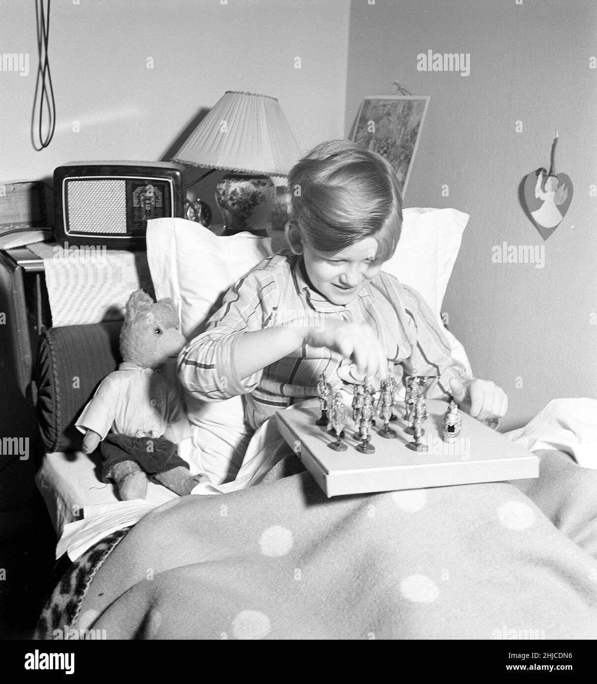 Toys in the 1940s. A boy in his bed is playing with toy soldiers. The german toys are made by Elastolin and features german soldiers in uniform. The figures were popular during the world war 2 even in other countries than Germany. Often with the nazi symbol featured on the flags and uniforms of the toys.  february 1940 Kristoffersson ref L79-3 Stock Photo