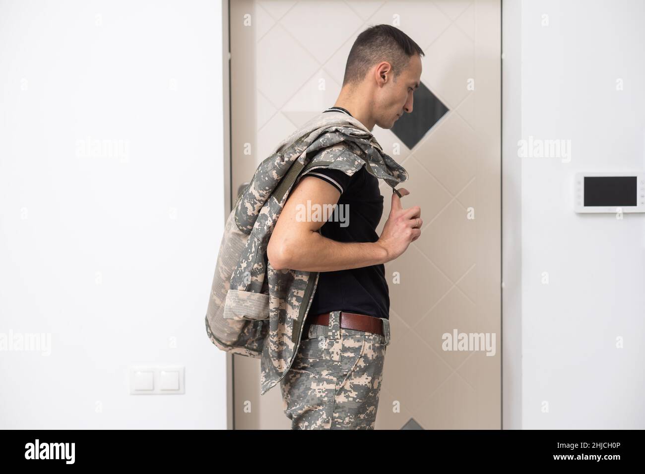 Soldier in camouflage standing near the door of house Stock Photo - Alamy