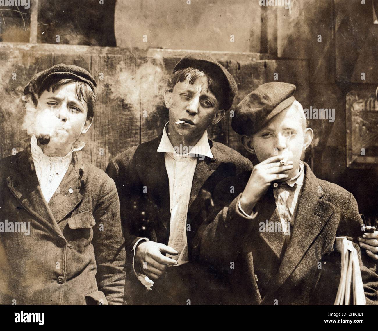 Newsies at Skeeter's Branch, on Jefferson near Franklin at 11:00 a.m. on Monday, May 9th, 1910. They were all smoking. Photographed by Lewis Hine in St. Louis, Missouri. Stock Photo