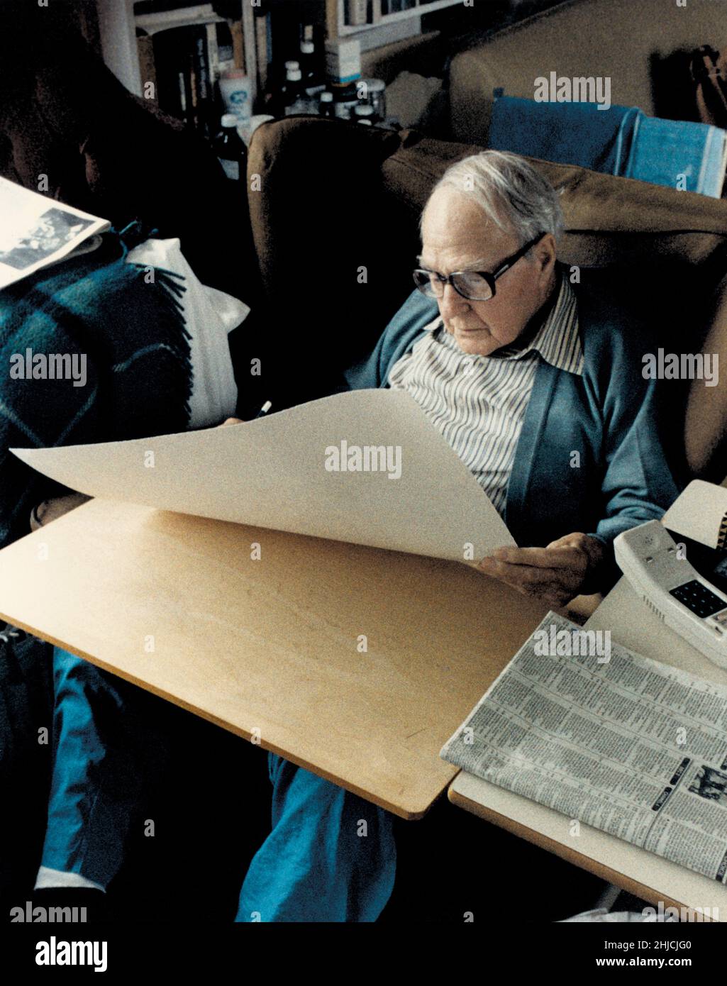 Sir Henry Spencer Moore signing prints at his home in Much Hadham, England, 1984. Moore was an English-born artist and sculptor, known for his modernist, abstract works. Born 1898, died 1986. Stock Photo