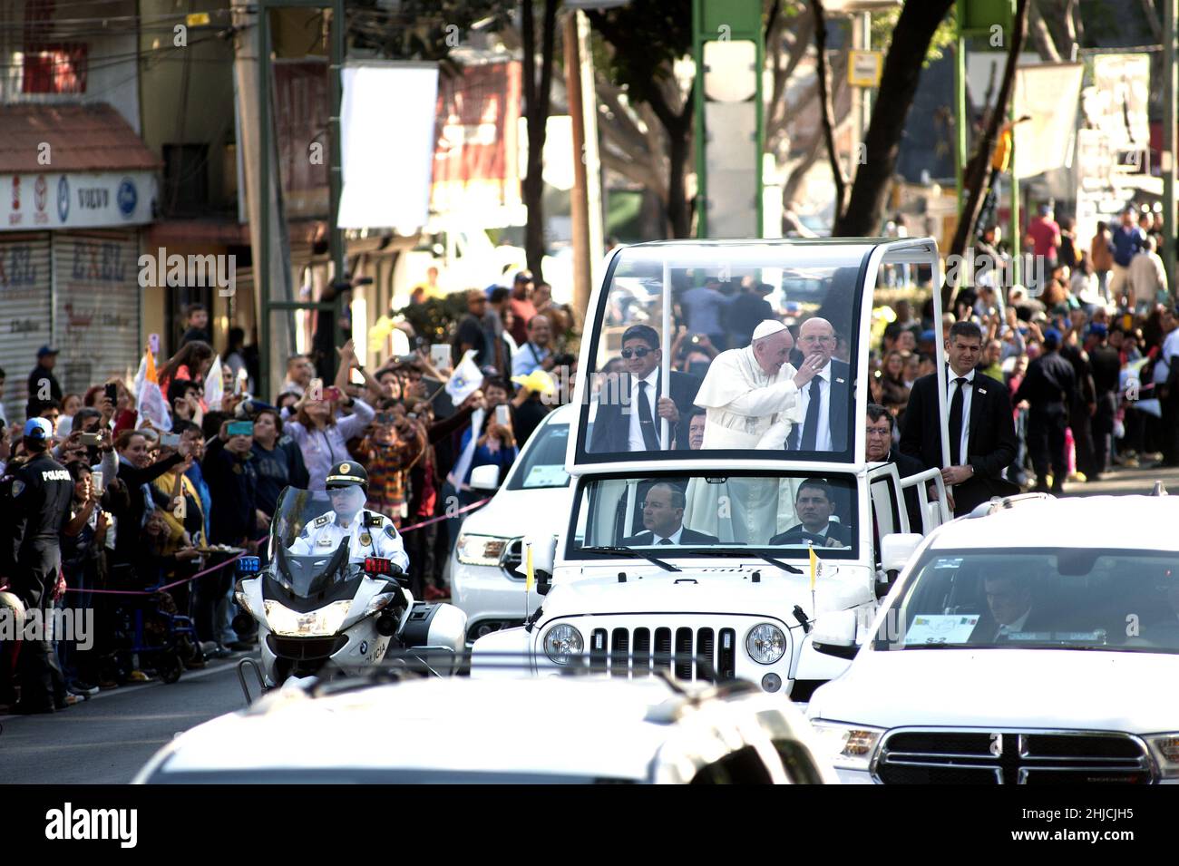 February 14, 2016; Mexico City, Mexico. Pope Francis riding in a Chrysler Jeep Wrangler popemobile speeds past crowds of waving Mexicans along a major avenue in Mexico City during his second full day of activities in the Mexican capital. Pope Francis spent 5 days in Mexico visiting cities all across Mexico recently torn by a brutal drug war, corruption, and economic problems. Stock Photo