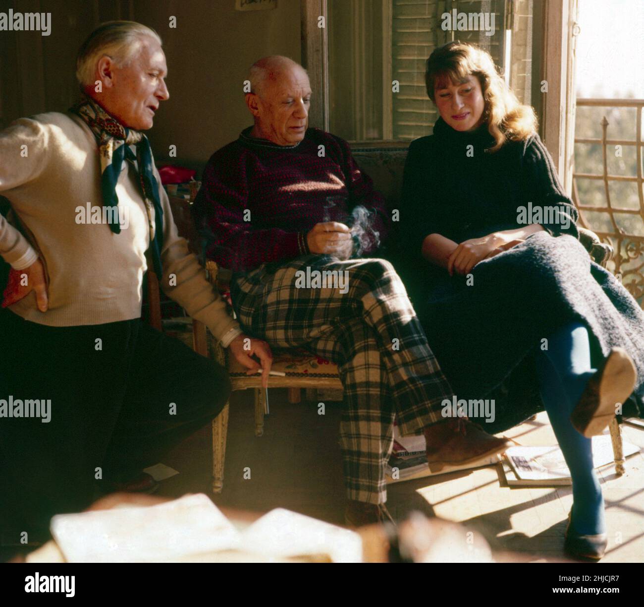 Artist Pablo Picasso (1881-1973) in Antibes, France, with Romuald Dor de la Souch√®re (left) and Marianne Greenwood (right). Dor de la Souch√®re wrote the book 'Picasso in Antibes,' a dummy of which can be seen in the photo. Marianne Greenwood (1916-2006), who took this photograph, was the in-house photographer for the Mus√©e Picasso. Stock Photo