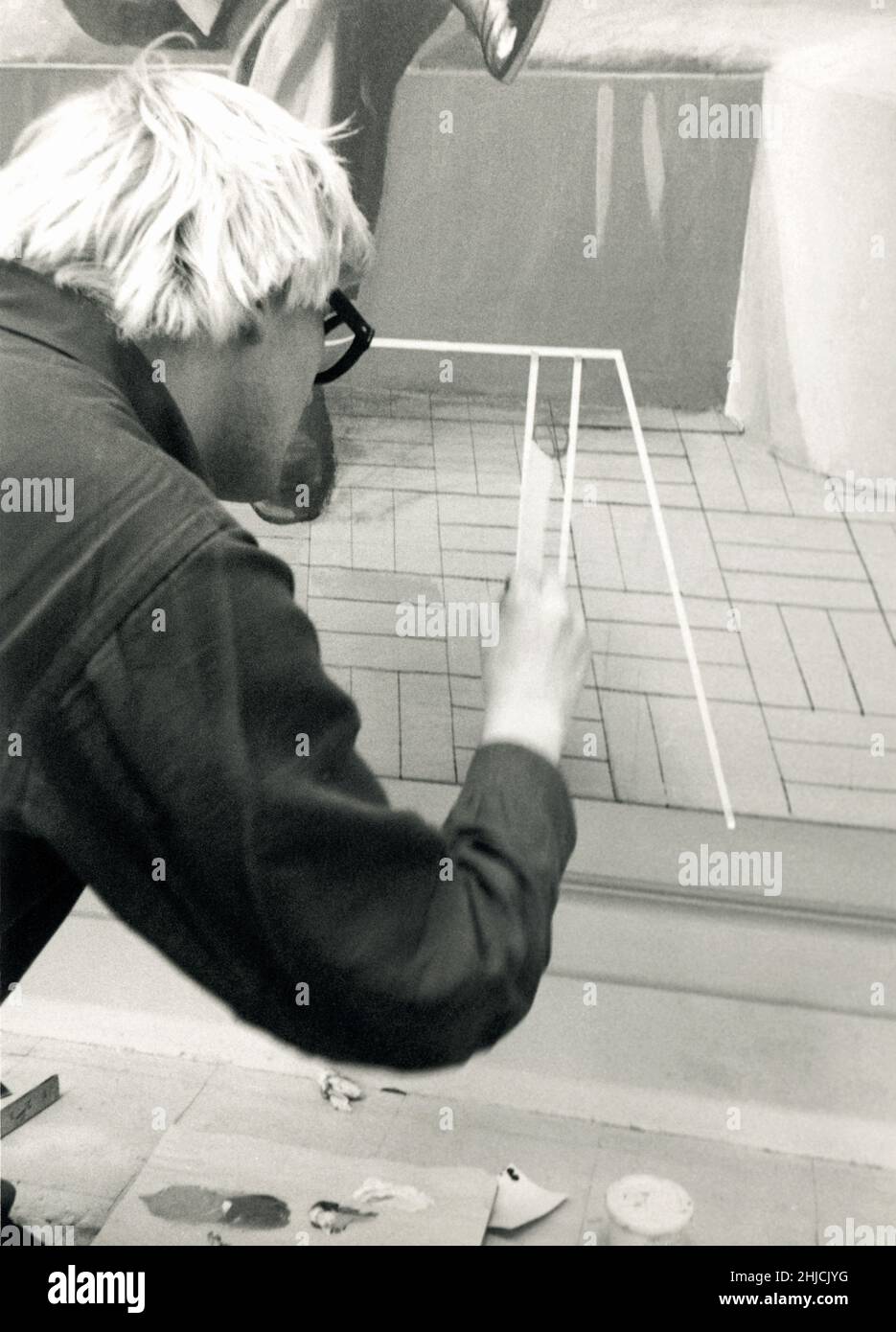 David Hockney works in his home studio on Powis Terrace in London, 1969. Here he is making his