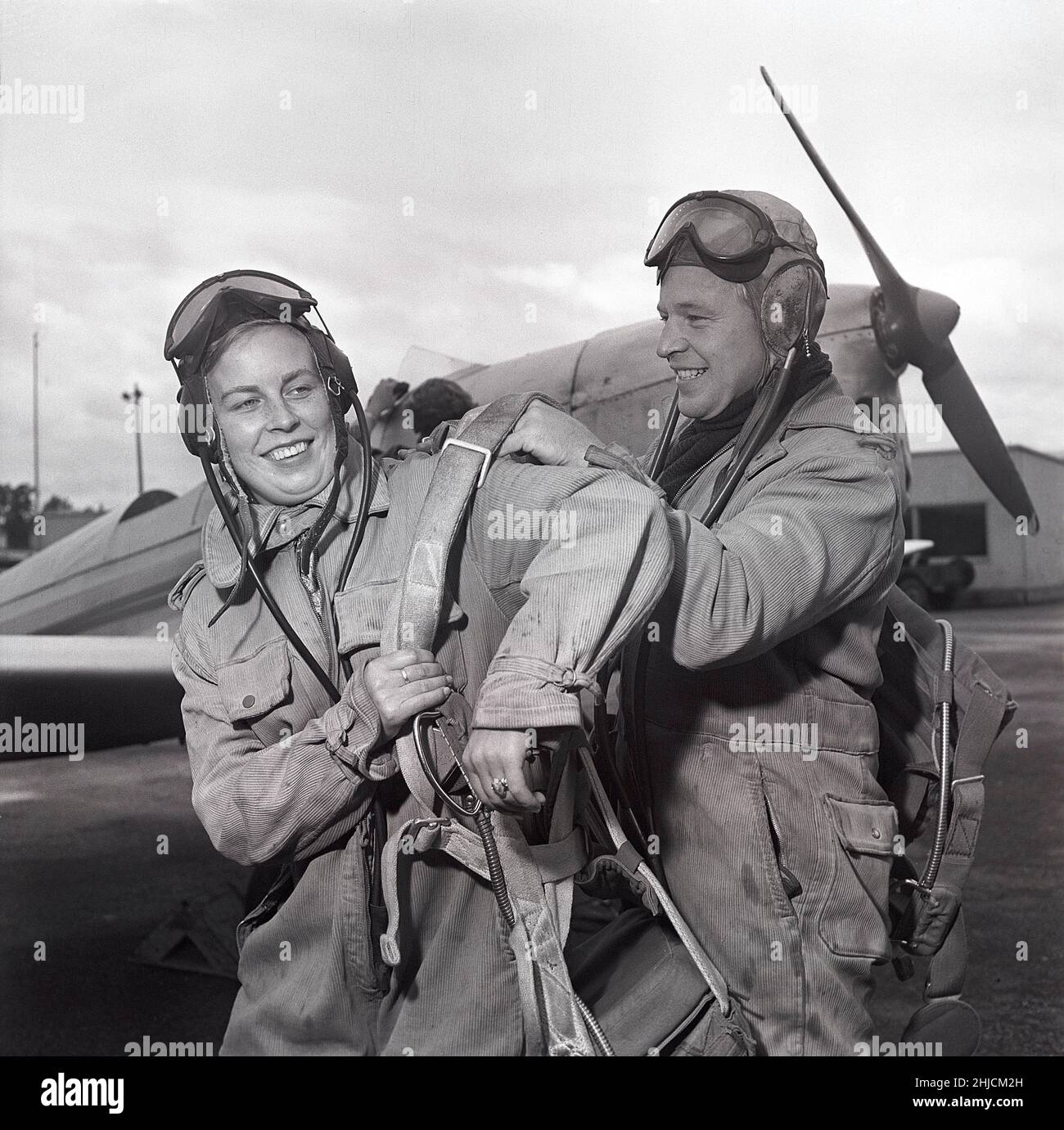 Pilot in the 1950s. Swedish Birgit Thuring 1912-1984. She is helped to put on here parachute before making the flight. Sweden 1950s Kristoffersson ref AT8-6 Stock Photo
