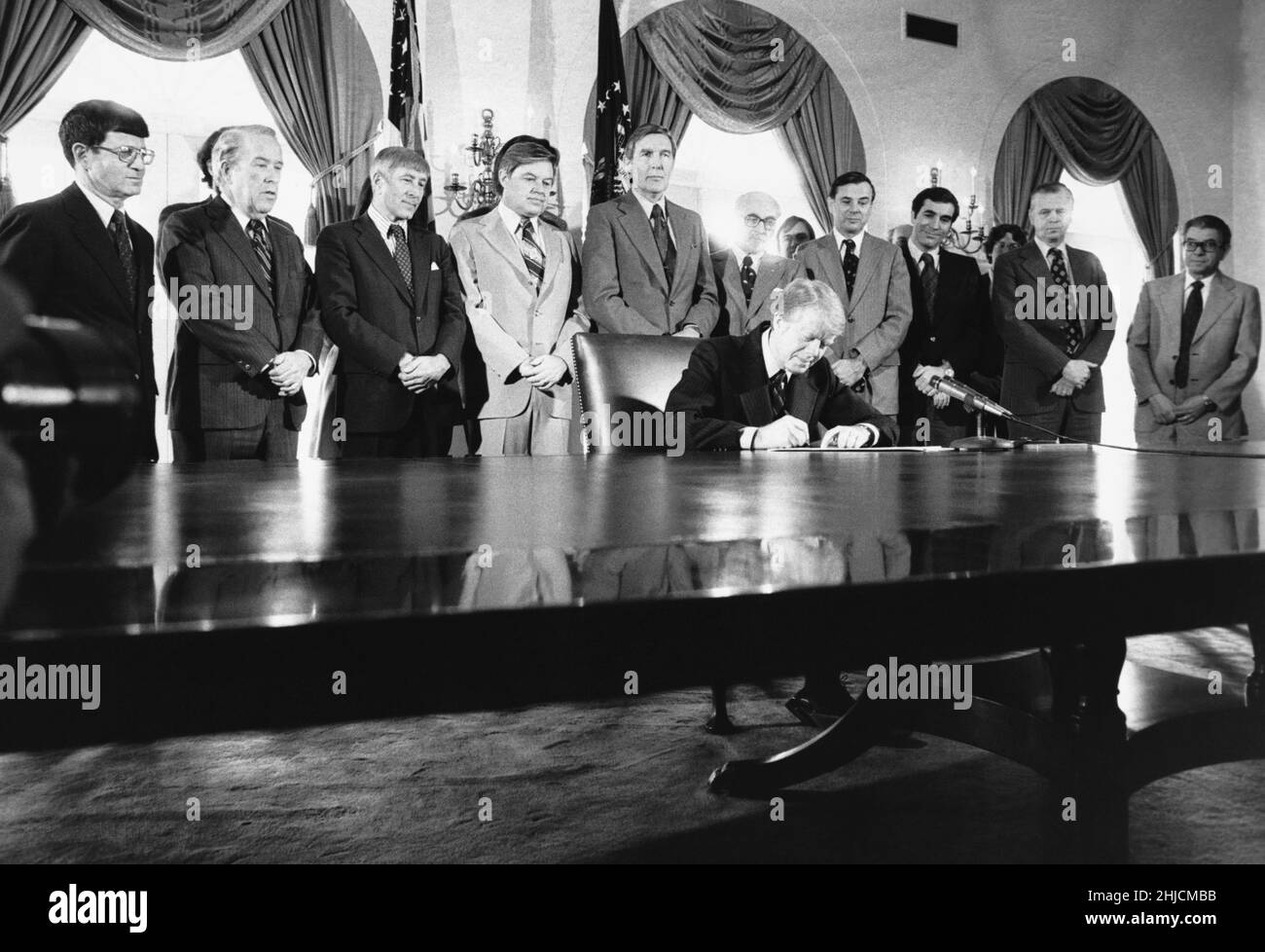 President Jimmy Carter (born October 1, 1924), surrounded by members of Congress, signs a bill into law. Circa 1980. Stock Photo