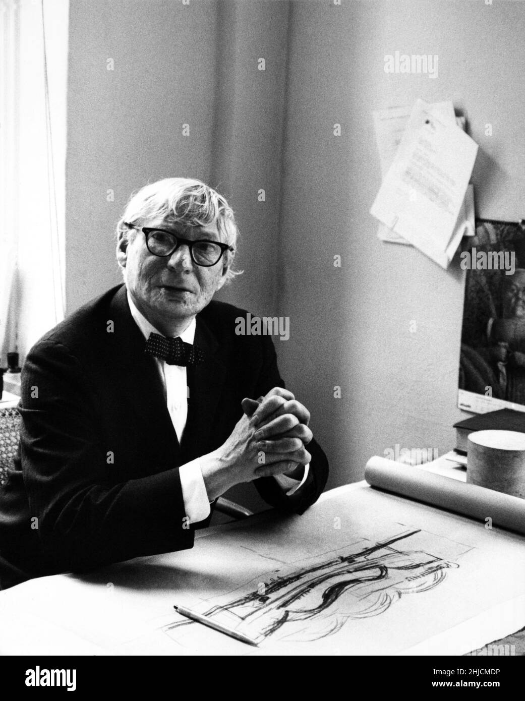 Architect Louis Kahn (1901 - 1974) sitting at a desk with architectural sketches. Circa 1970. Stock Photo
