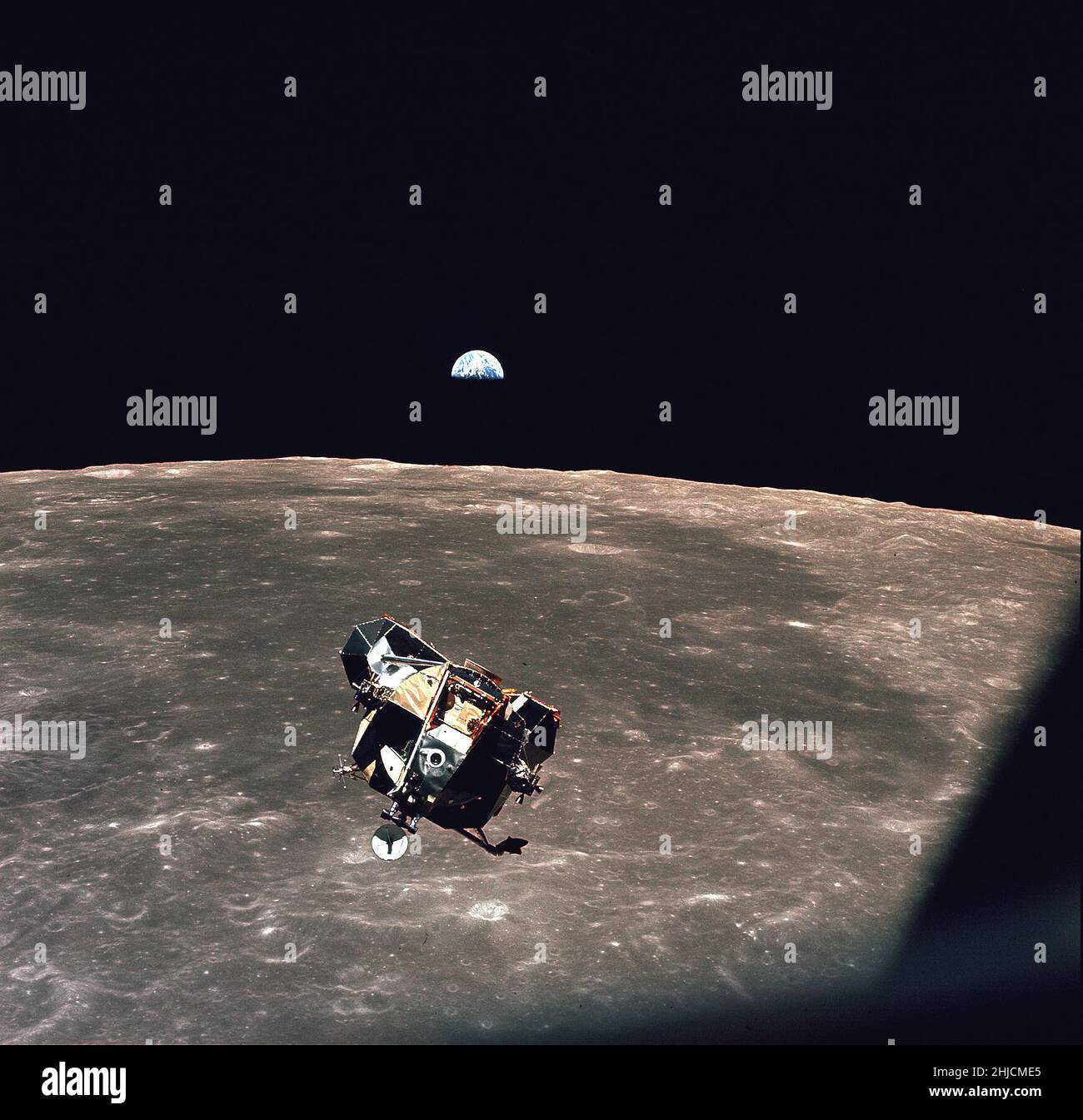 A view of the Apollo 11 lunar module 'Eagle' as it returned from the surface of the moon to dock with the command module 'Columbia'. A smooth mare area is visible on the Moon below and a half-illuminated Earth hangs over the horizon. The lunar module ascent stage was about 4 meters across. Command module pilot Michael Collins took this picture just before docking at 21:34:00 UT (5:34 p.m. EDT) 21 July 1969. Stock Photo