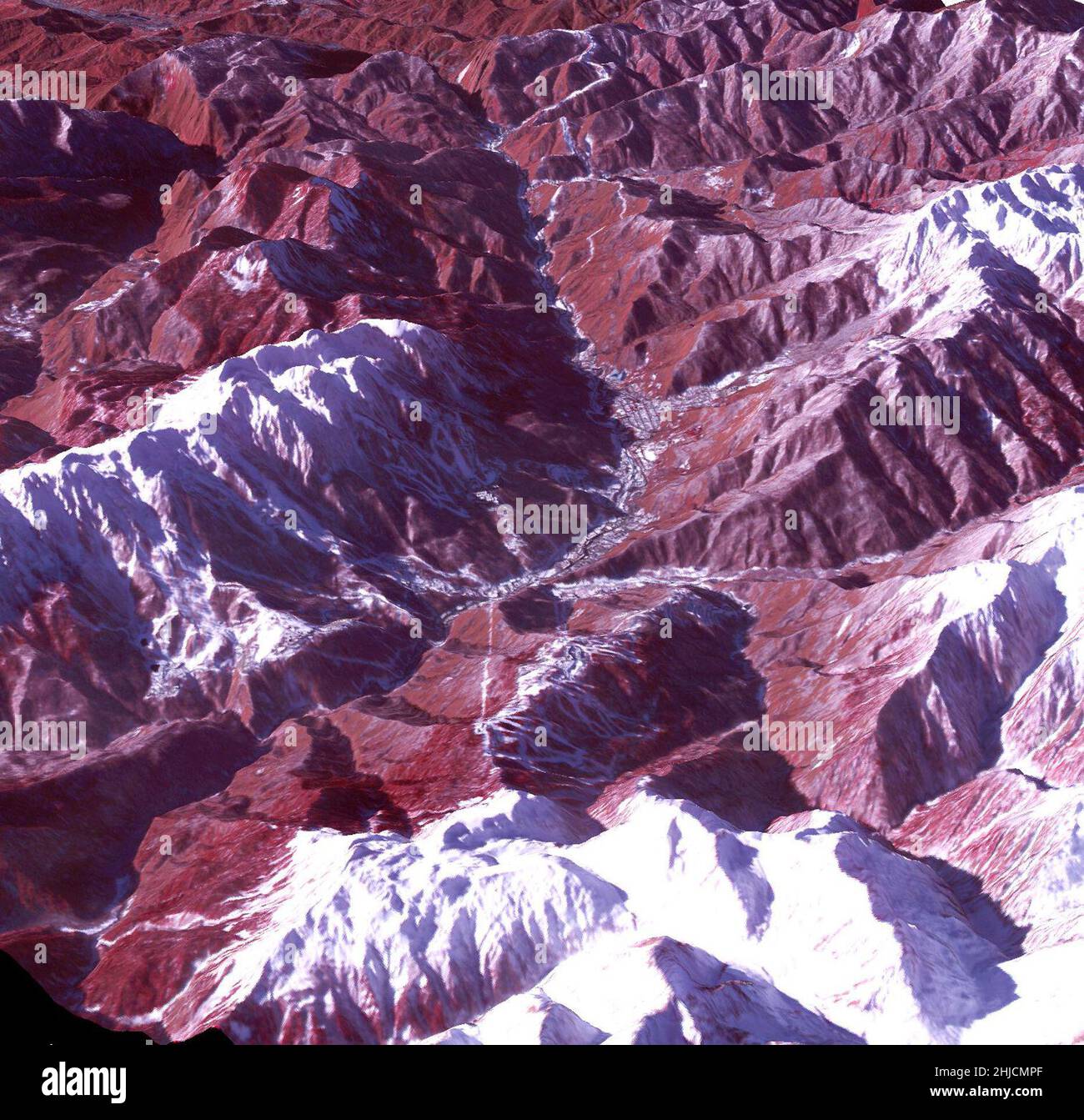 False color Image of the skiing and snowboarding sites for the 2014 Winter Olympics in Sochi, Russia, acquired on Jan. 4, 2014, by the Advanced Spaceborne Thermal Emission and Reflection Radiometer (ASTER) instrument on NASA's Terra spacecraft. Rosa Khutar ski resort near Sochi, Russia, is in the valley at center, and the runs are visible on the shadowed slopes on the left-hand side of the valley. Height has been exaggerated 1.5 times to bring out topographic details.  In this southwest-looking image, red indicates vegetation, white is snow, and the resort site appears in gray. Stock Photo