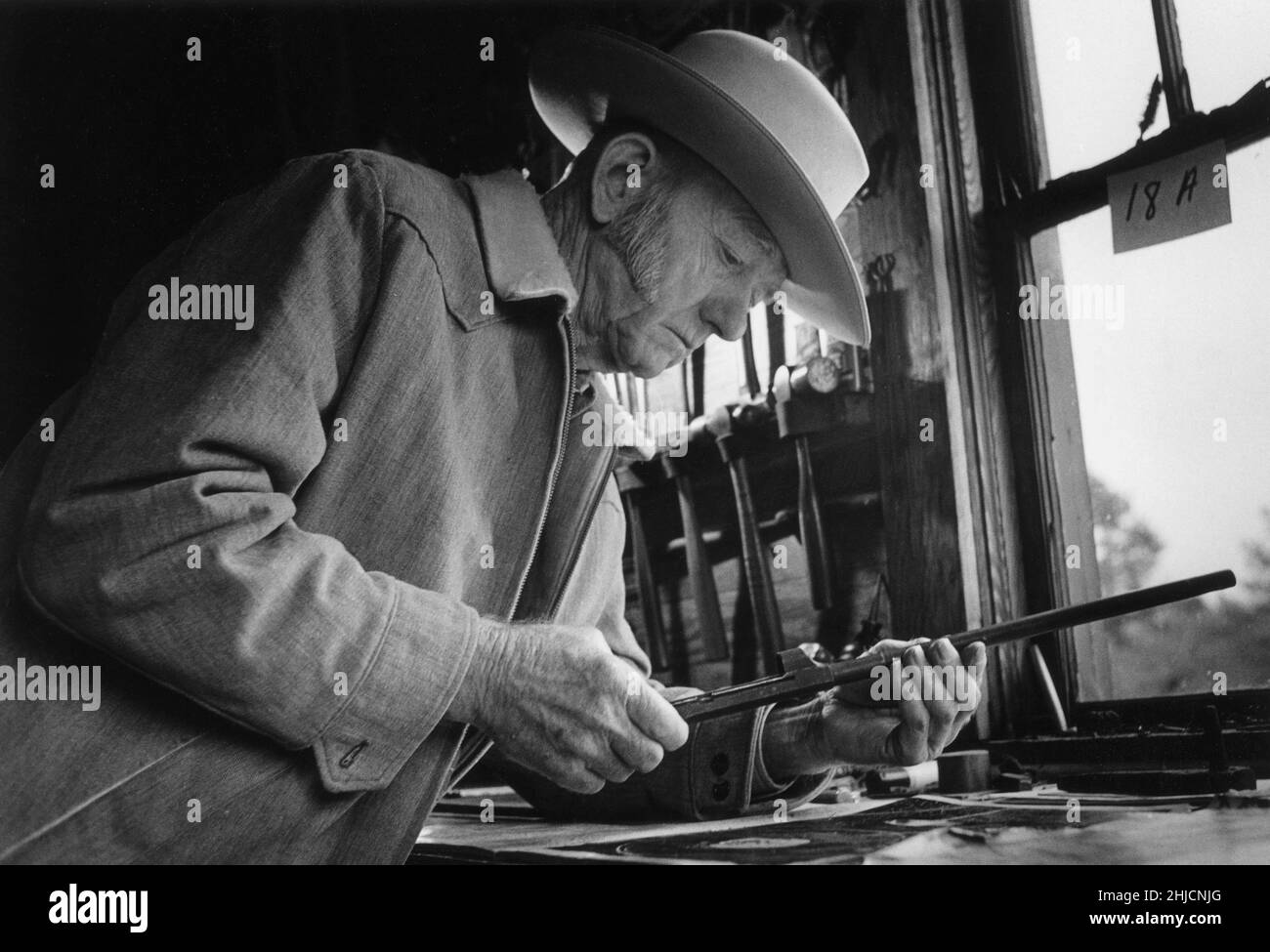 Carbine Williams invented the M-1 Carbine, which was the basic weapon for soldiers during WWII. He created the carbine while serving time in prison in NC on a moonshine charge. The prison warden allowed him to work on this project, and Carbine became famous for his invention. In the picture, he is at work in his gun shop near Fayetteville, NC, before the shop was moved near the Hall of History, in Raleigh. Douglas MacArthur once said, 'Without Carbine's carbine, the US might not have won WWII.' Stock Photo