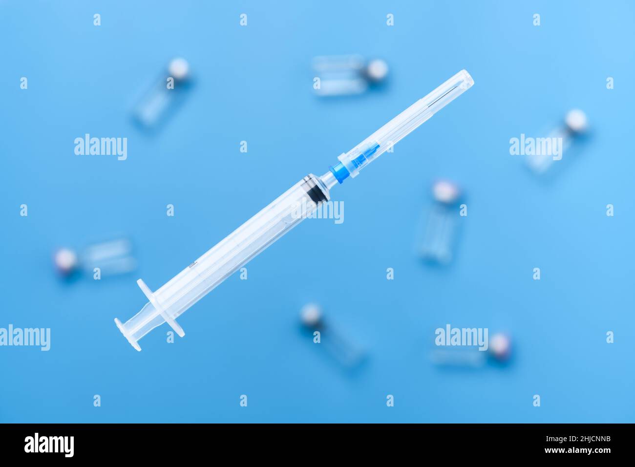 Flying syringe for vaccination against coronavirus infection, at the bottom of the tablet. Medicine and healthcare concept Stock Photo