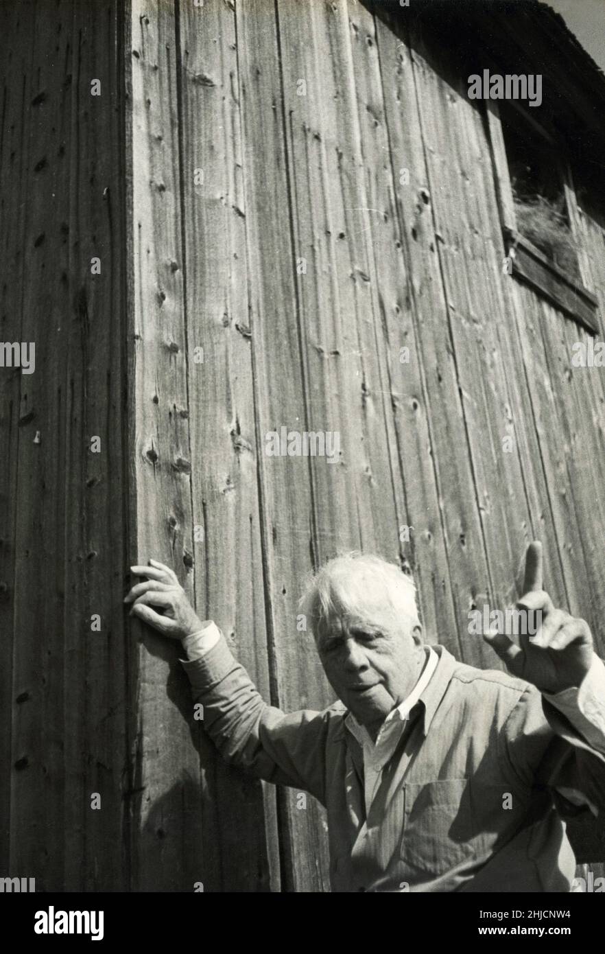 New England poet Robert Frost (1874 - 1963) standing by a barn on his farm near Ripton, Vermont. Famous for poems such as 'Stopping by Woods on a Snowy Evening' and 'The Road Not Taken,' Frost won four Pulitzer Prizes during his life. Stock Photo