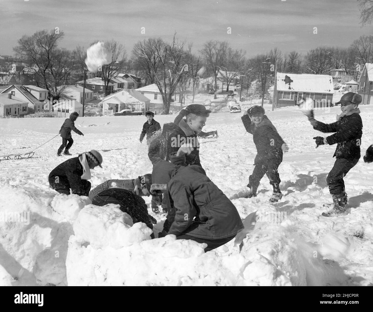 A snowball fight breaks out among a group of schoolboys at Thorpe Gordon School in Jefferson City, Missouri. Photographed by Ralph Walker, circa 1950s. Stock Photo