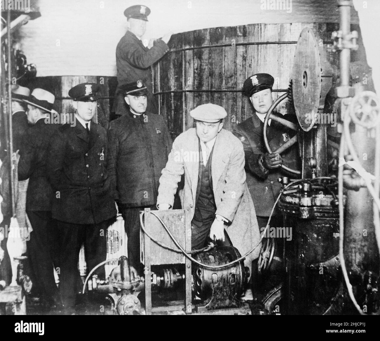 Detroit police inspecting equipment found in a clandestine underground brewery during the prohibition era, circa 1920s. Stock Photo