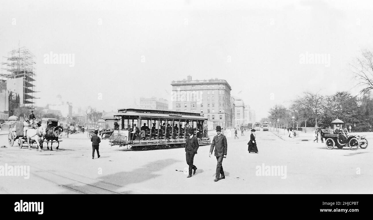The Eighth Avenue trolley sharing the street with a horse-drawn produce wagon and an open automobile. Downtown, New York City, looking north, 1904. Stock Photo