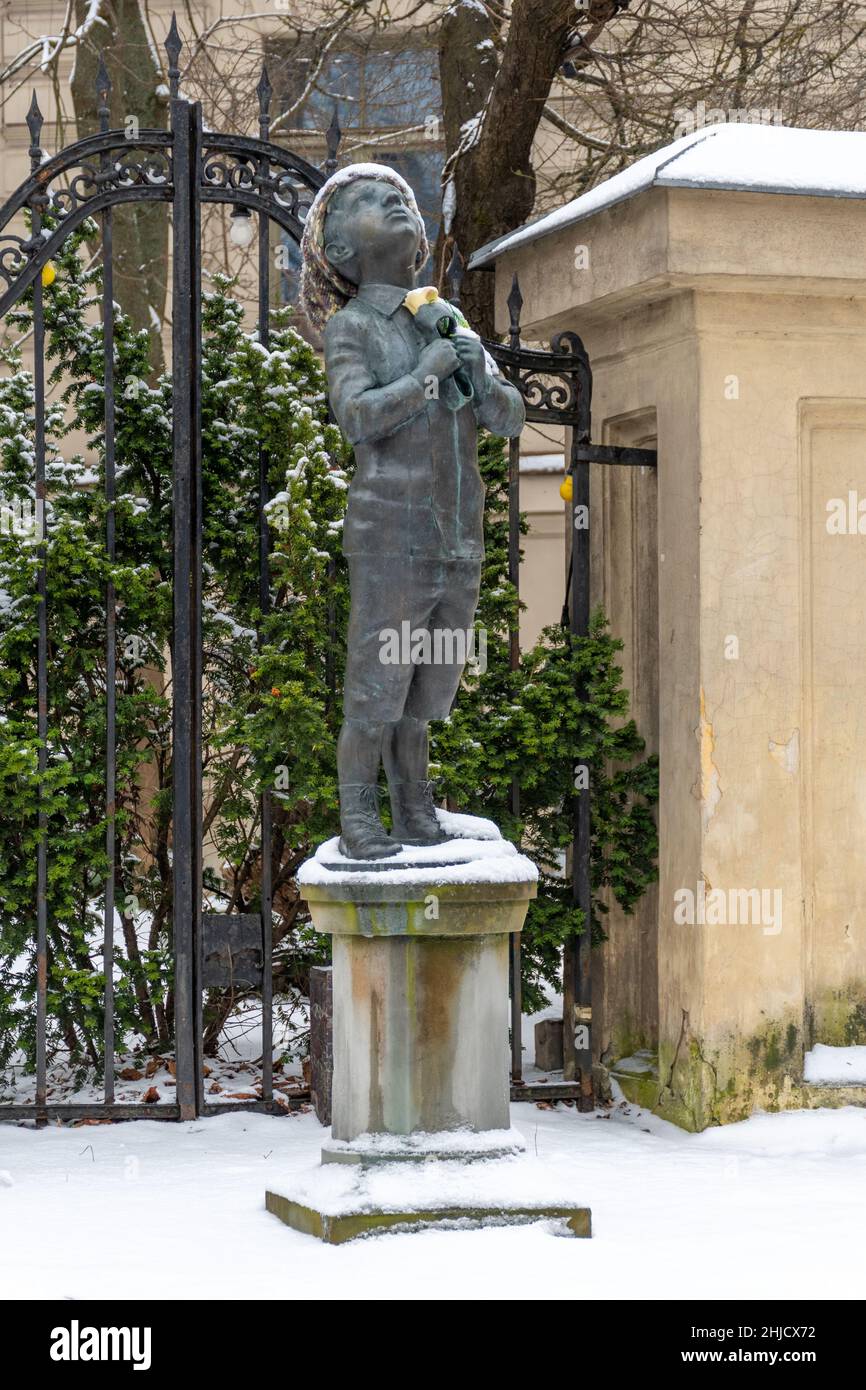 Romain Gary bronze statue of a boy clutching a galosh and looking to the sky made by lithuanian artist Romualdas Kvintas, vertical Stock Photo