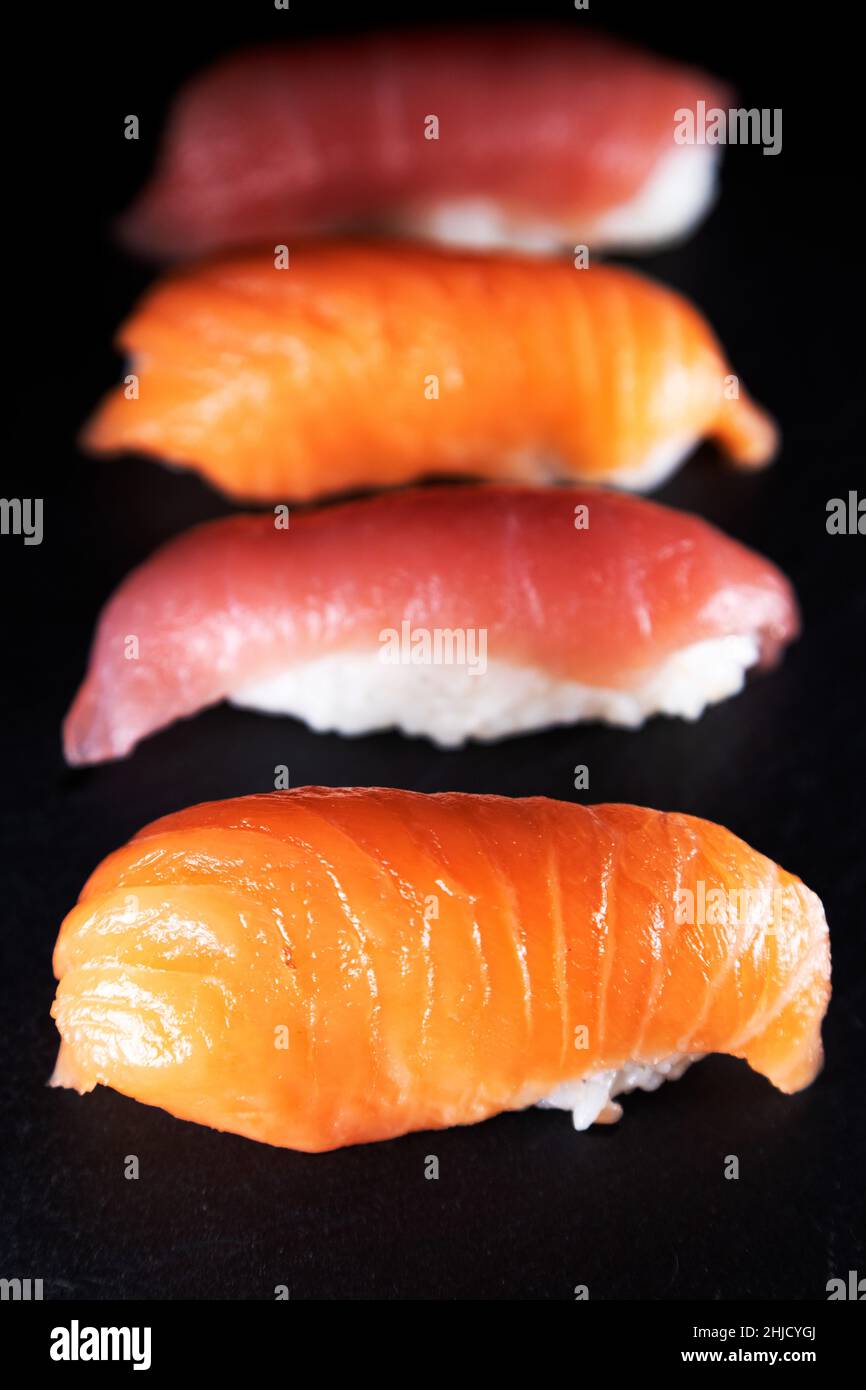 A platter of tuna and salmon nigiri. Types of sushi, the dish originated in Japan and features thinly sliced raw fish served over white rice mixed wit Stock Photo