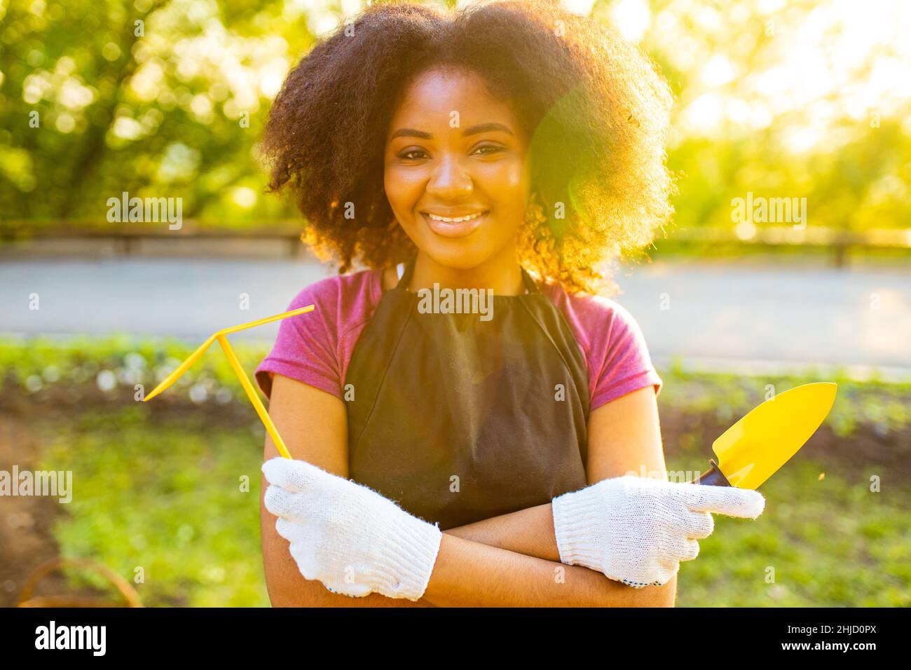 brazilian woman with cool afro curls hairstyle in the garden spring time at sunset Stock Photo