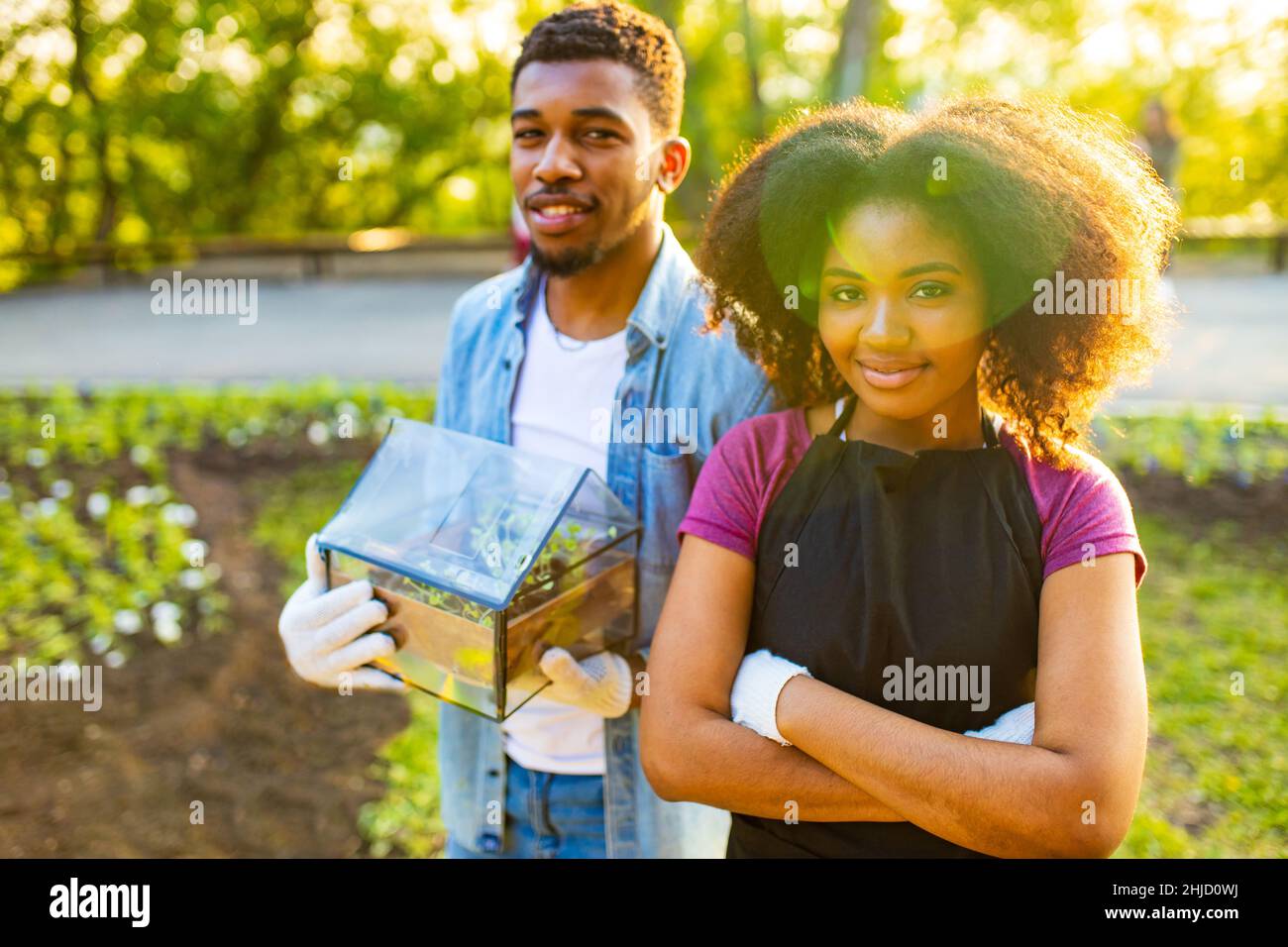 afro american couple gardening outdoors at sunset sunny spring day Stock Photo