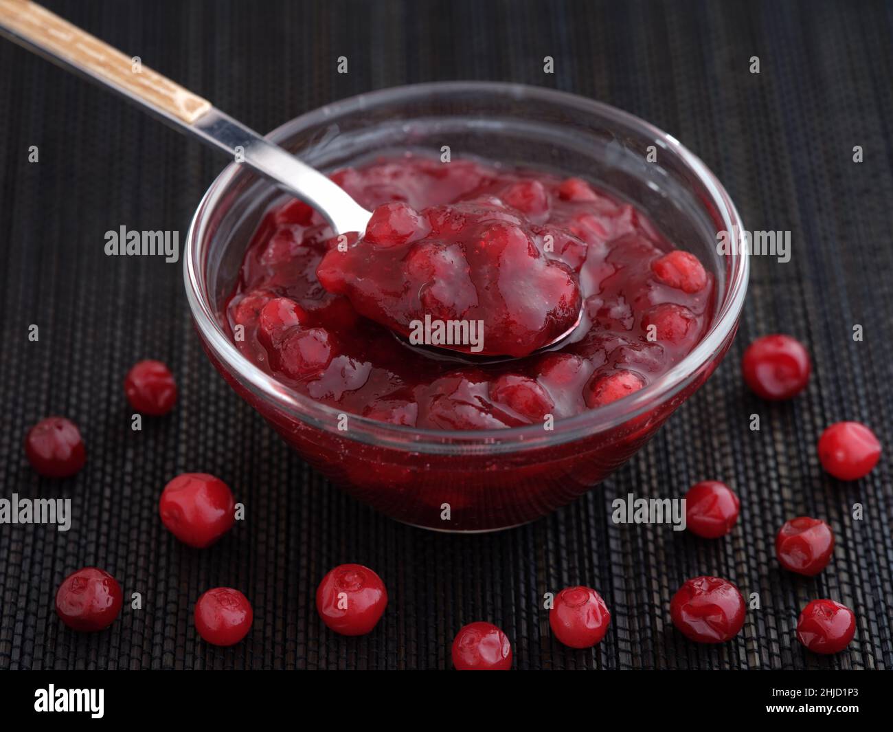 Homemade wild lingonberry jam in a glass bowl. Low key. Close up. Stock Photo