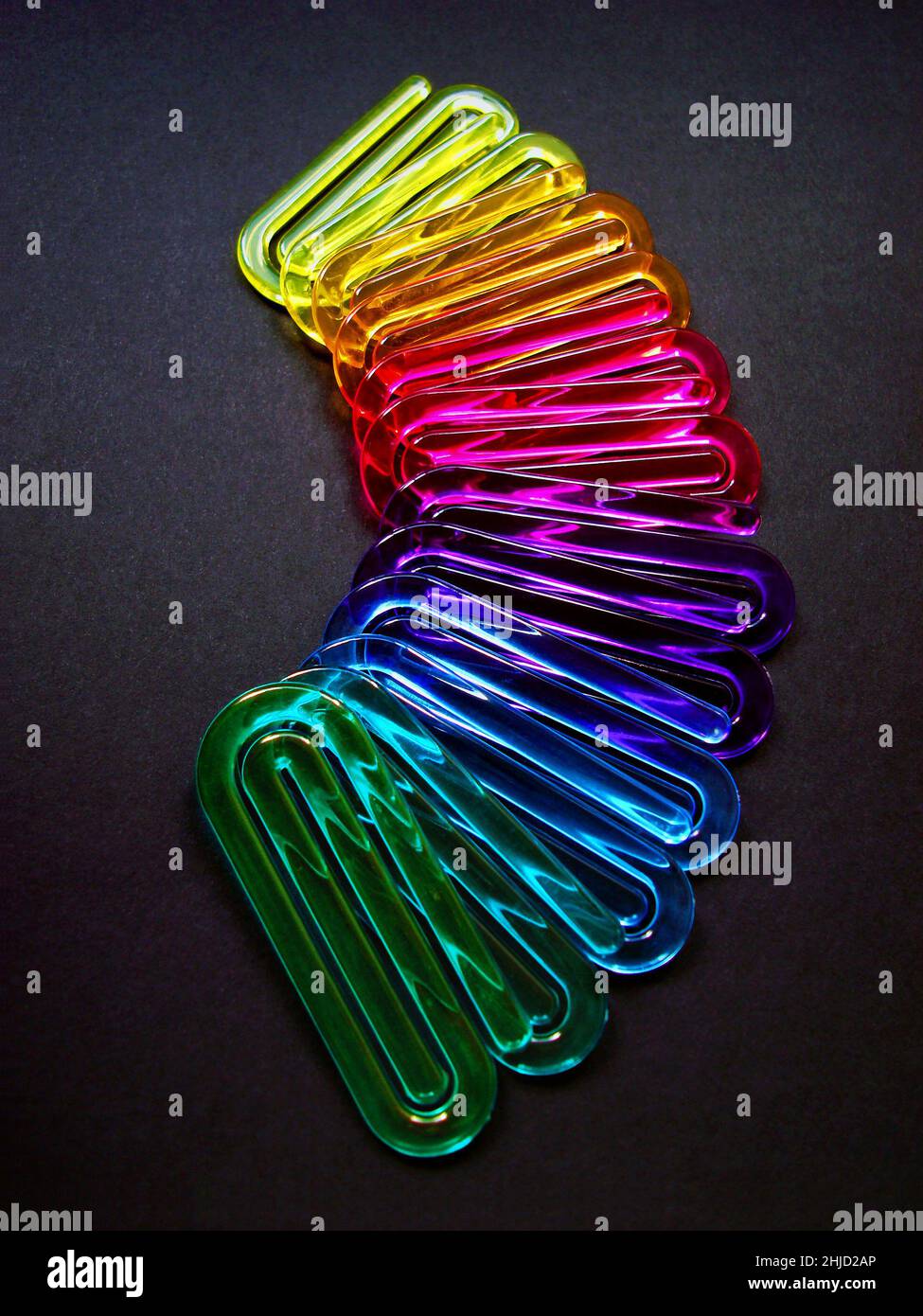 Acrylic paper clips on black background Stock Photo