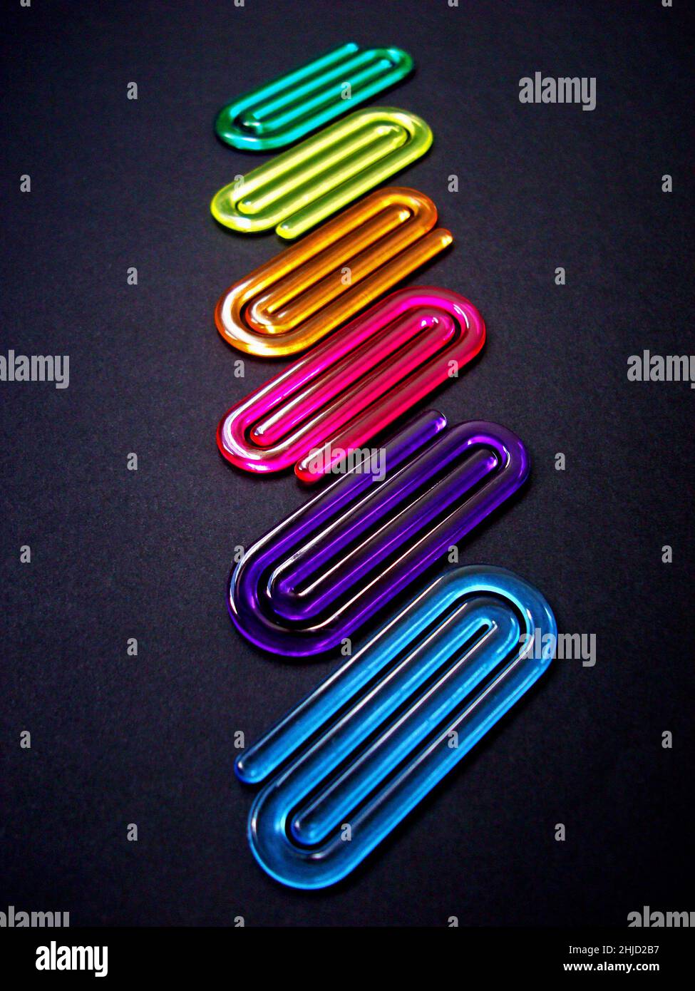 Acrylic paper clips on black background Stock Photo