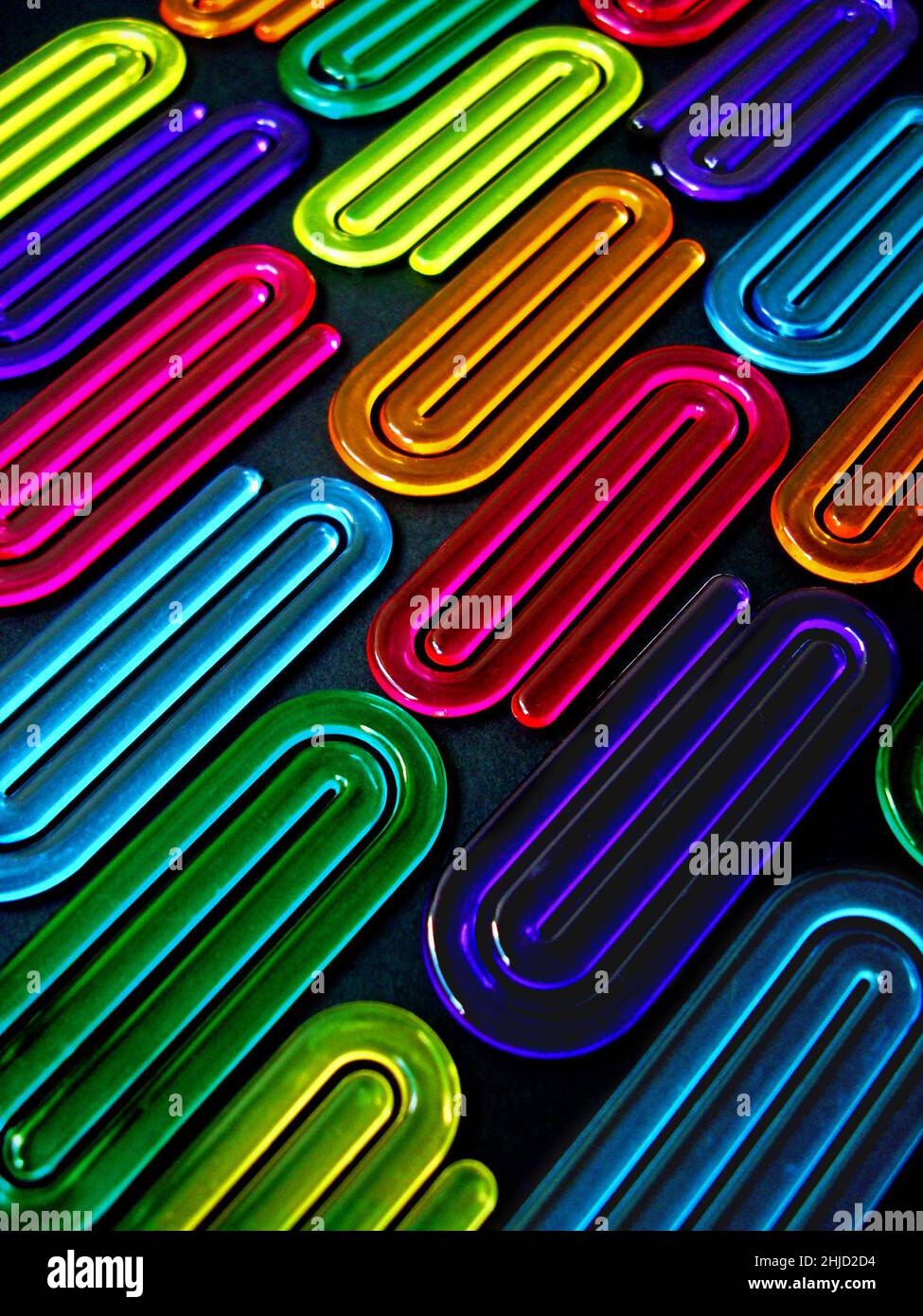 Acrylic paper clips on black background Stock Photo