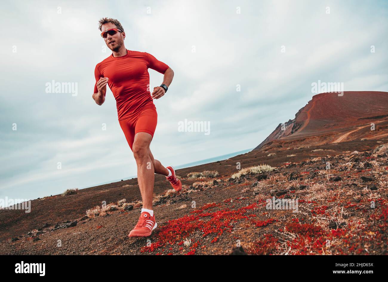 Running marathon man runner sport athlete training ultra running on long distance endurance trail race wearing compression clothes, sunglasses Stock Photo