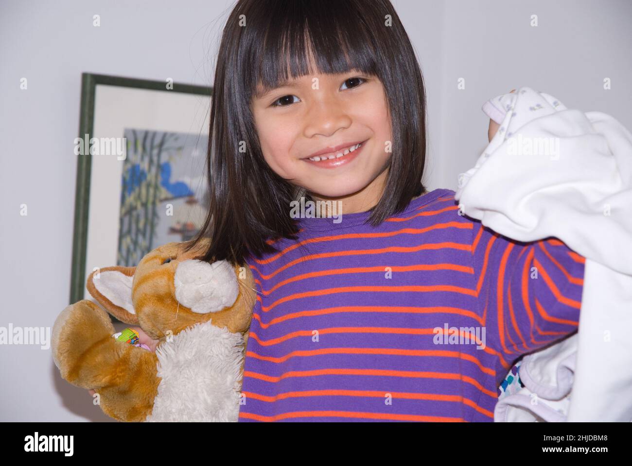 5 year old girl holding favorite stuffed toy animal and blanket Stock Photo