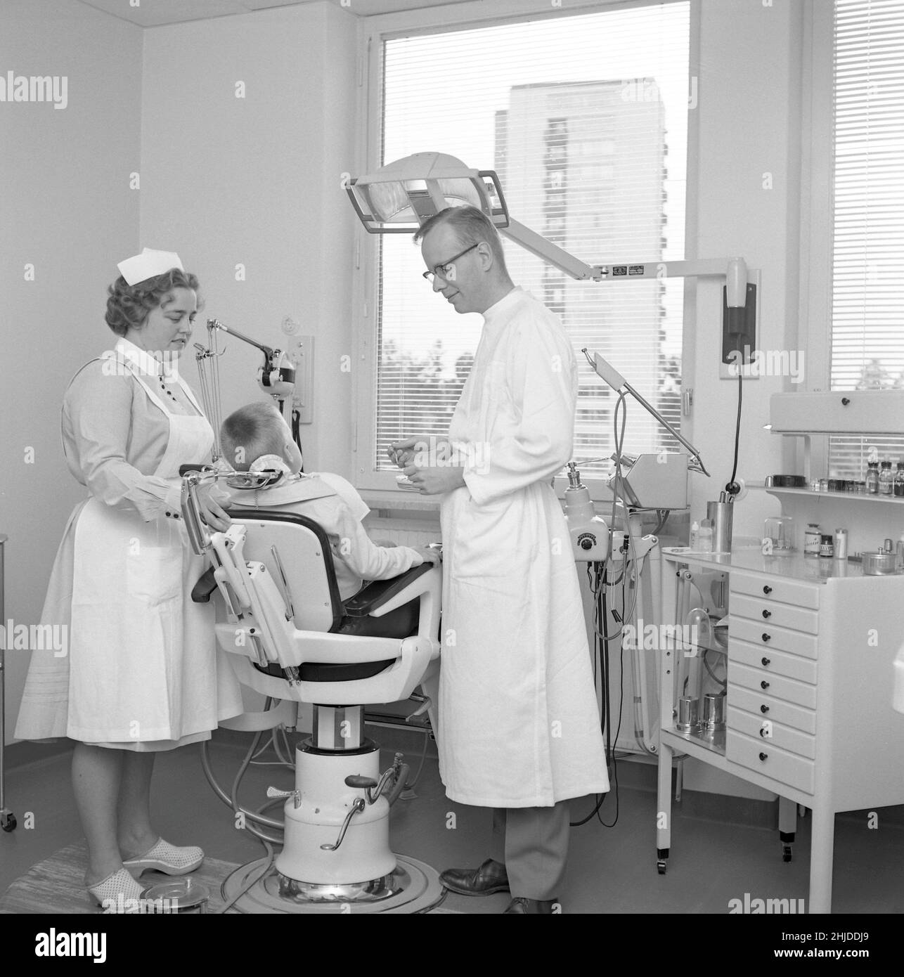 At the dentist in the 1960s. A boy is being examined and treated by a dentist. A nurse is assisting.  Sweden july 5 1962. Stock Photo