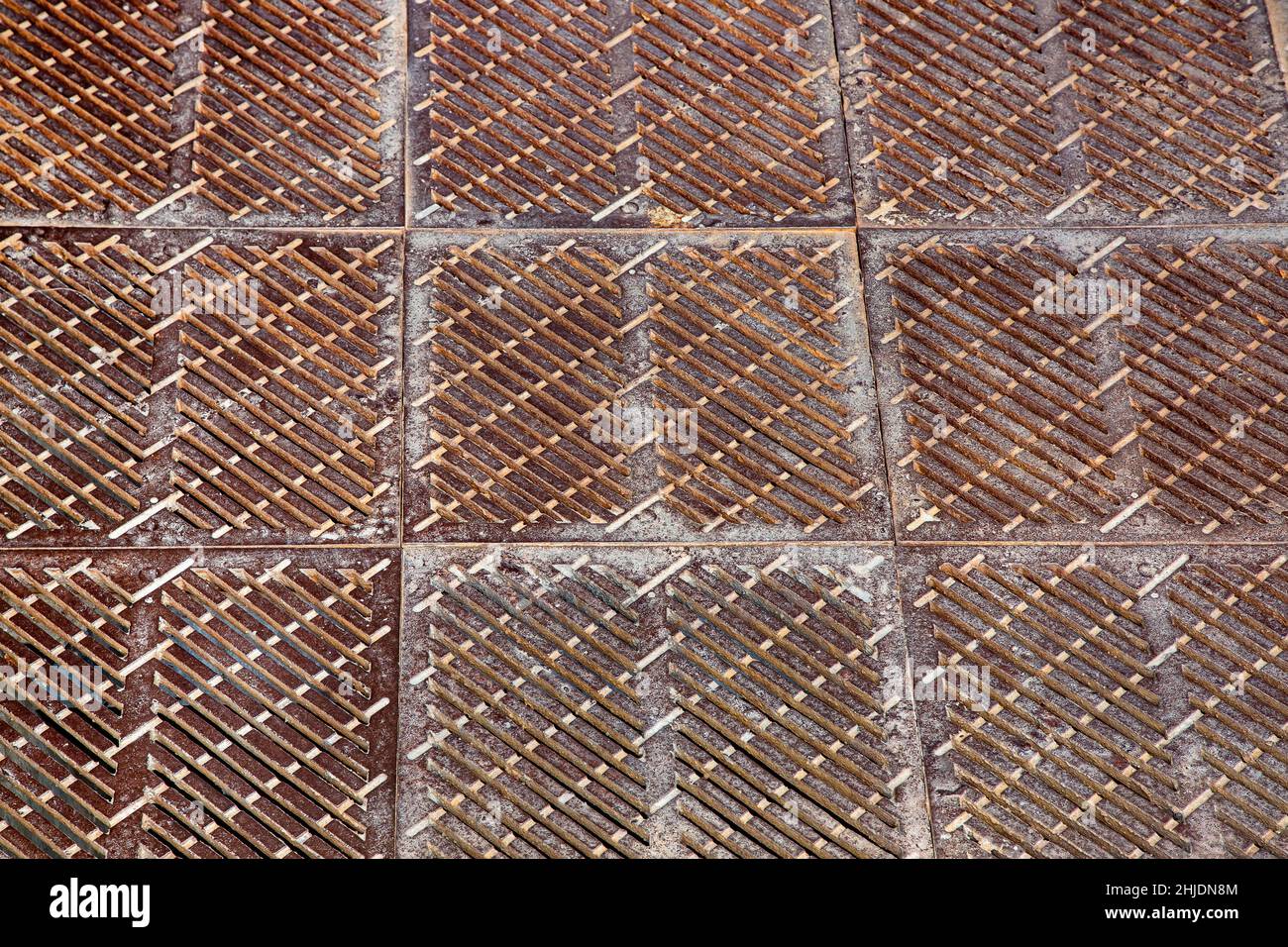 old rusty square shaped drainage grate, the surface of the storm system on the floor close-up. Stock Photo