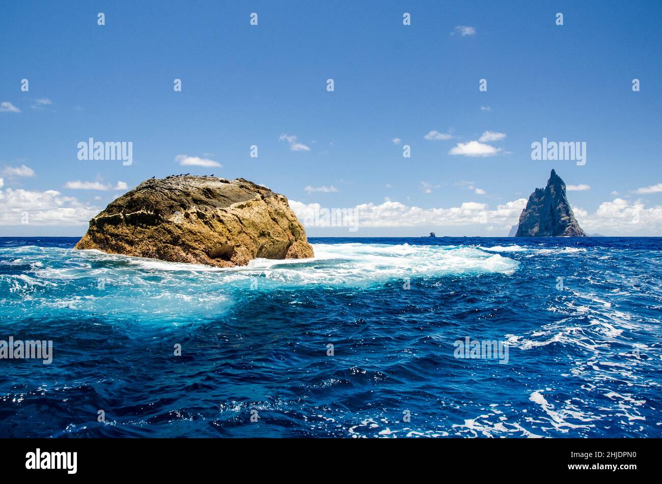 This exposed and infrequently-dived site is Southeast Pinnacle, with Ball's Pyramid in the distance. Lord Howe Island, Pacific Ocean, Australia, Tasma Stock Photo
